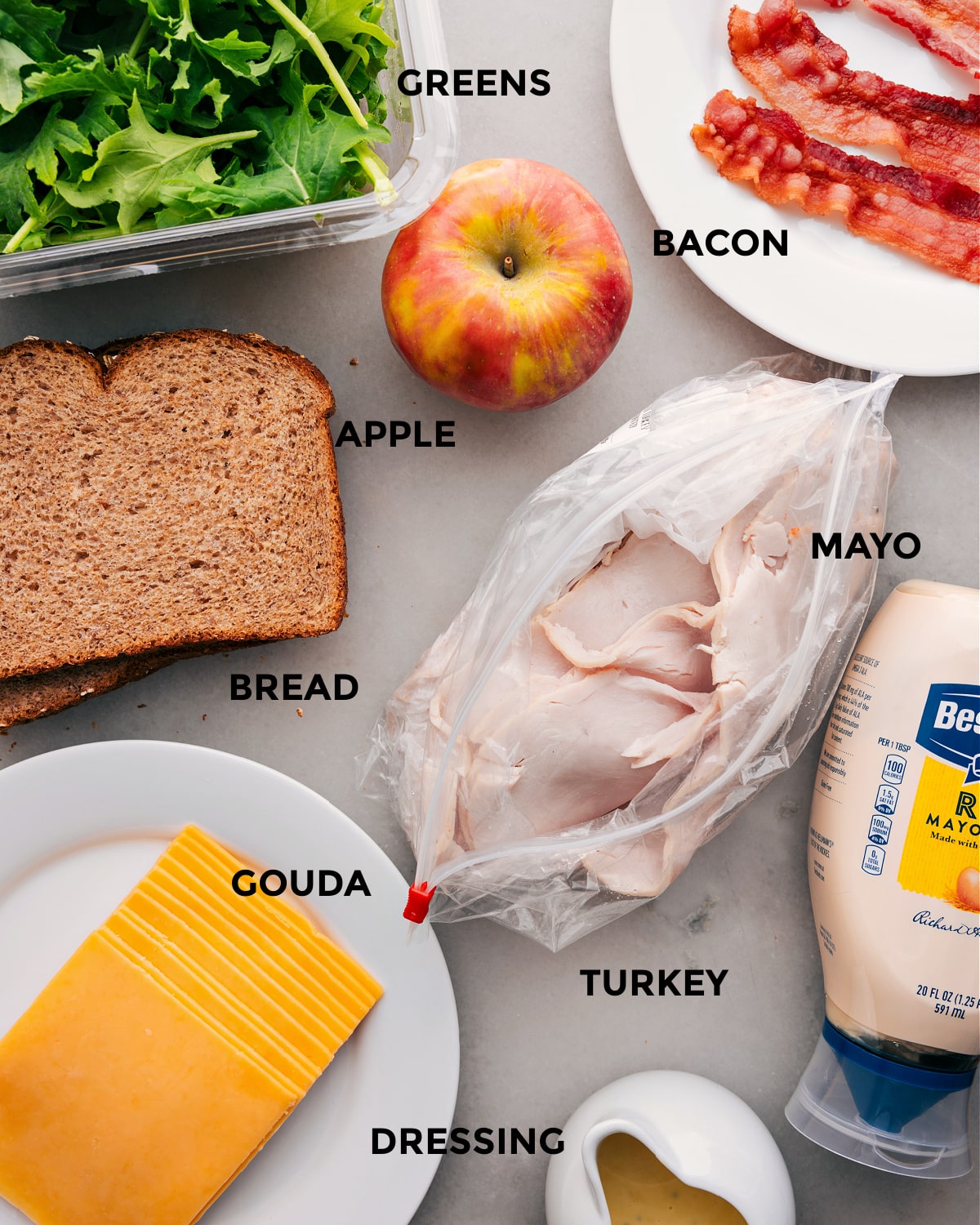 Ingredients In This Turkey Sandwich All the ingredients in this recipe, including the meats, apple, greens, bread, cheese, mayo, and dressing, are prepped for easy assembly.