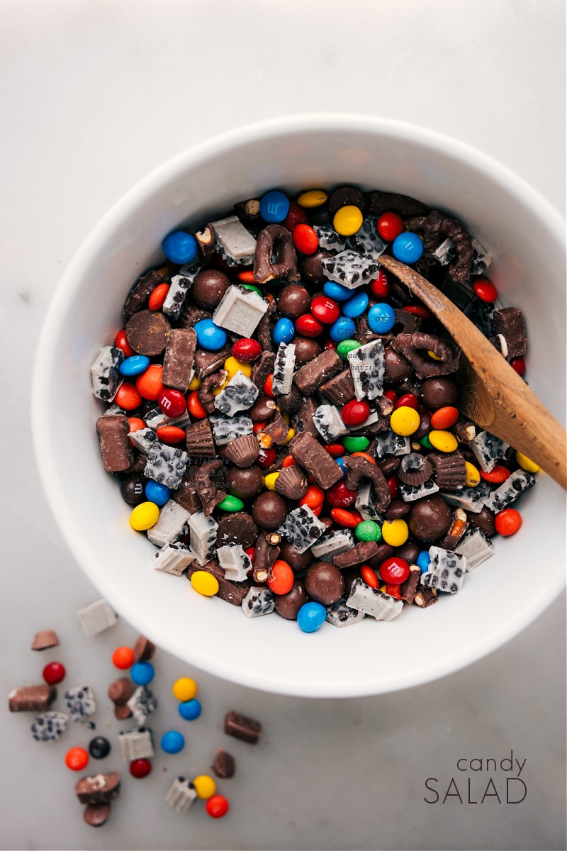 Candy Salad is the most fun mishmash of sweet and salty flavors, featuring standouts like Whoppers, Reese's, and chocolate-covered pretzels. It's the perfect treat for when you're craving a combo of the most iconic candies in one bite or looking for a surefire hit at your next gathering! Recipe via chelseasmessyapron #dessert #treat #movienight #snack #movienighttreats #candy #salad #candysalad Overhead image of Candy Salad in a bowl