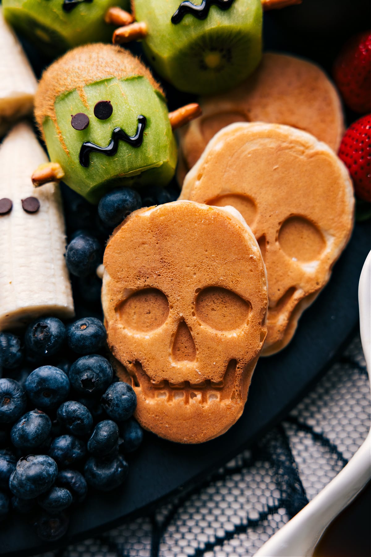 Skull-shaped pancakes for Halloween breakfast Pancakes shaped like skulls, cooked and ready to eat.