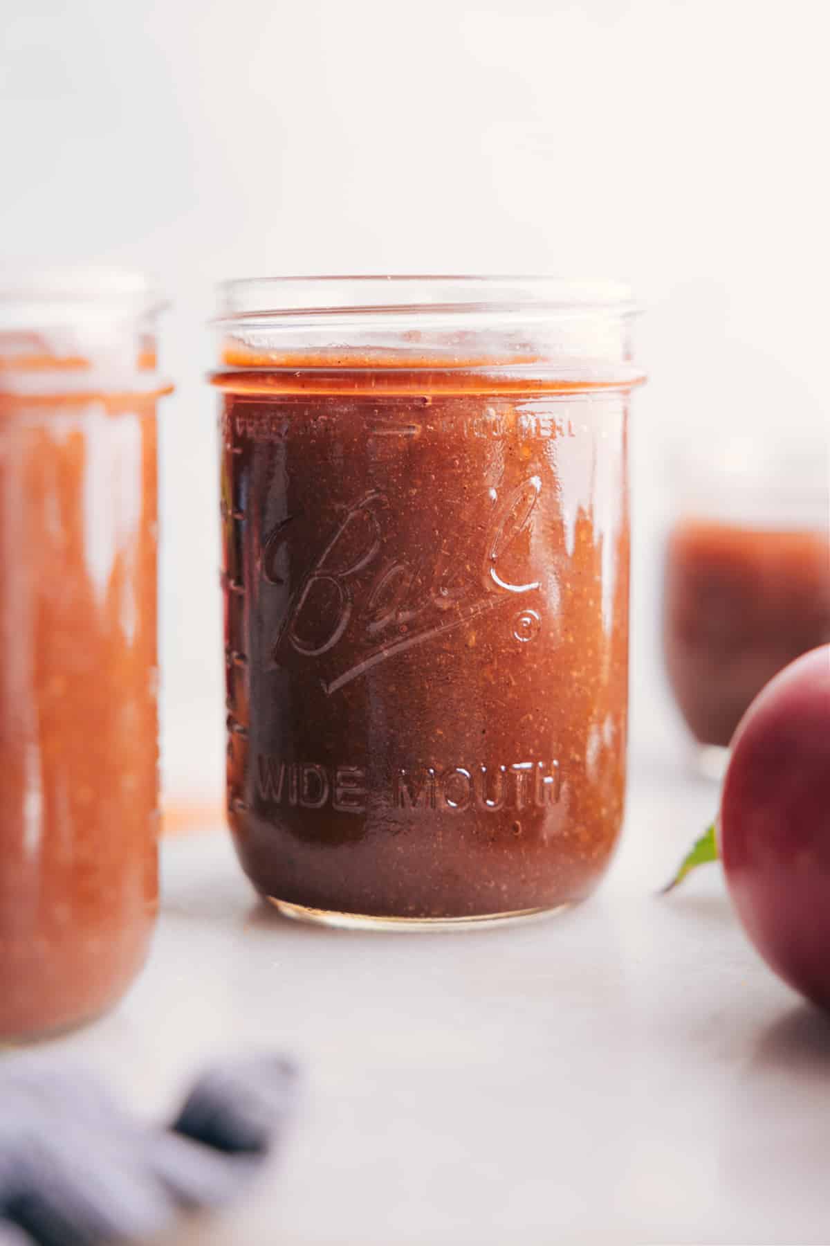 Glass jar filled with rich, smooth Crockpot Apple Butter.