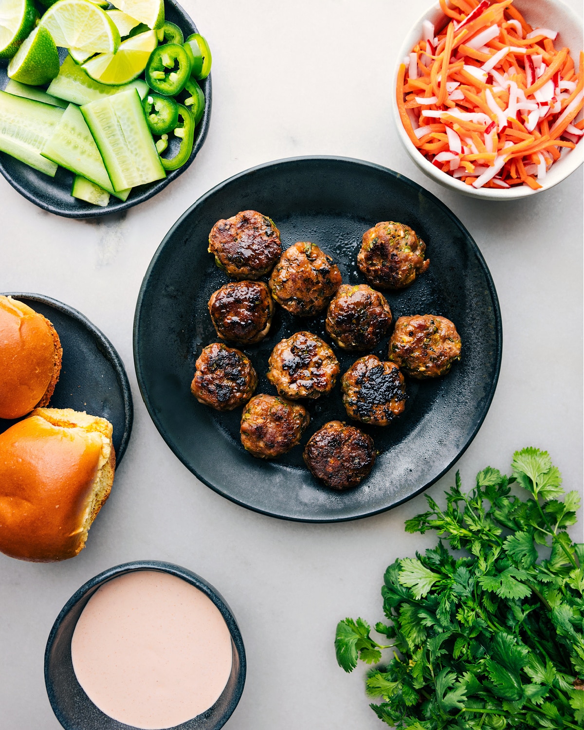 Pristine pork Banh Mi Meatballs amid the assembly ingredients Perfectly baked pork banh mi meatballs presented amid an array of fresh ingredients, poised for slider assembly.