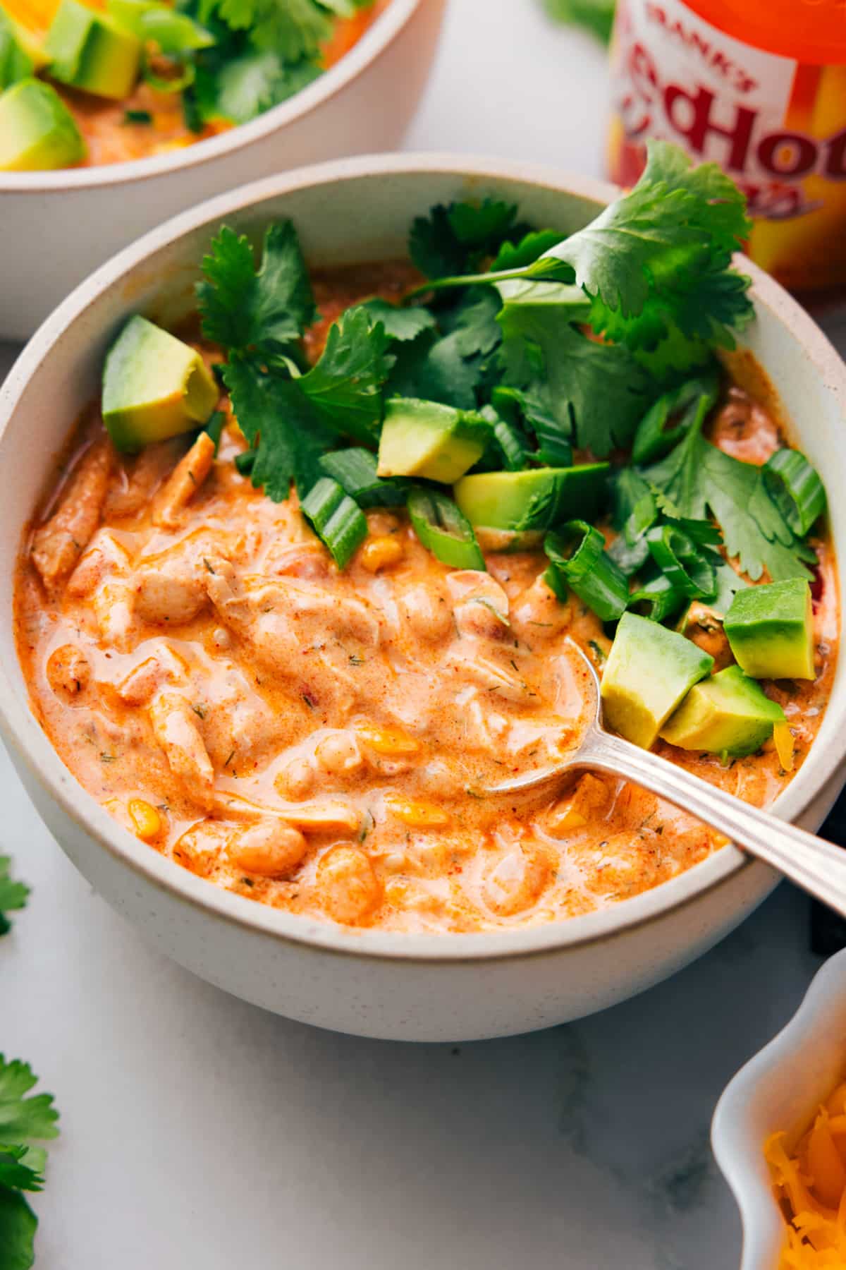 Buffalo Chicken Chili Is A Total Crowd-Pleaser A big bowl of Buffalo Chicken Chili with a spoon in it.