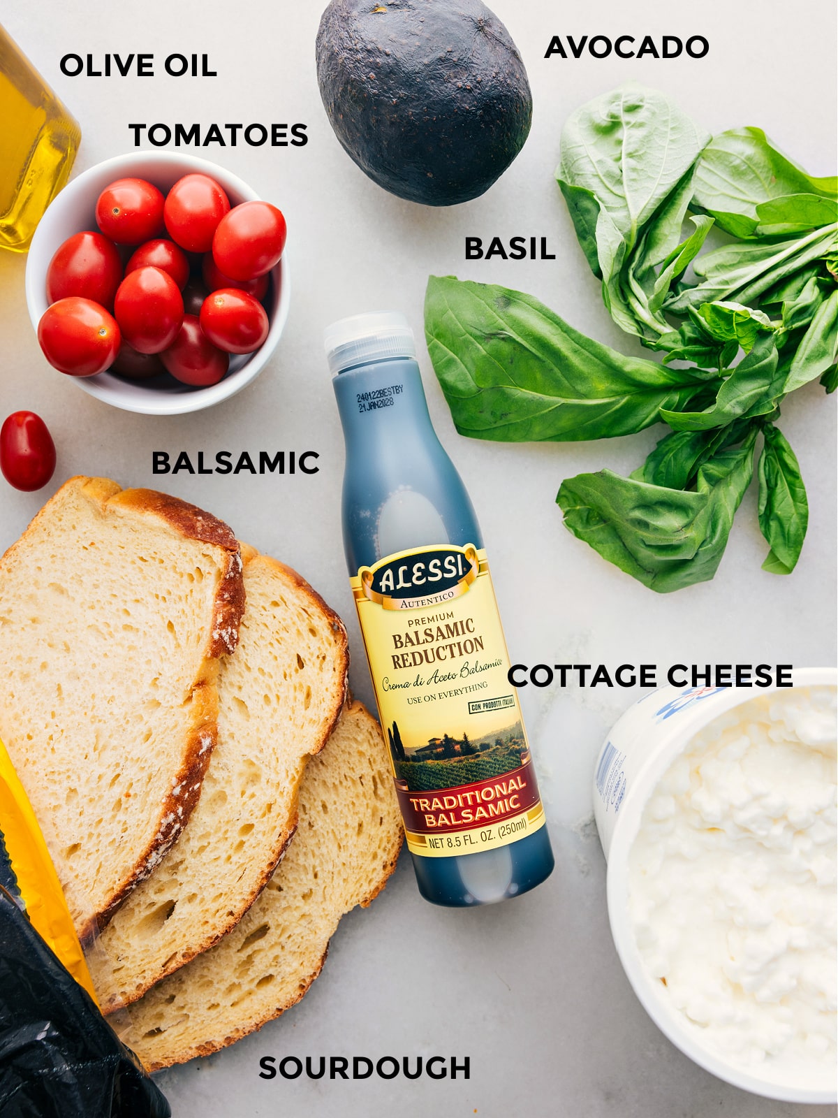 Ingredients In Cottage Cheese Toast All the ingredients used in this recipe including sourdough, cottage cheese, tomatoes, olive oil, avocado, basil, and balsamic reduction prepped out for easy assembly.