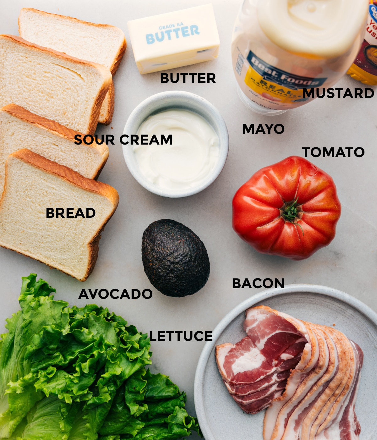 Ingredients In A Bacon Lettuce And Tomato Sandwich All the ingredients in this recipe including bread, sour cream, butter, mustard, mayo, tomato, bacon, avocado, and lettuce prepped out for easy assembly.