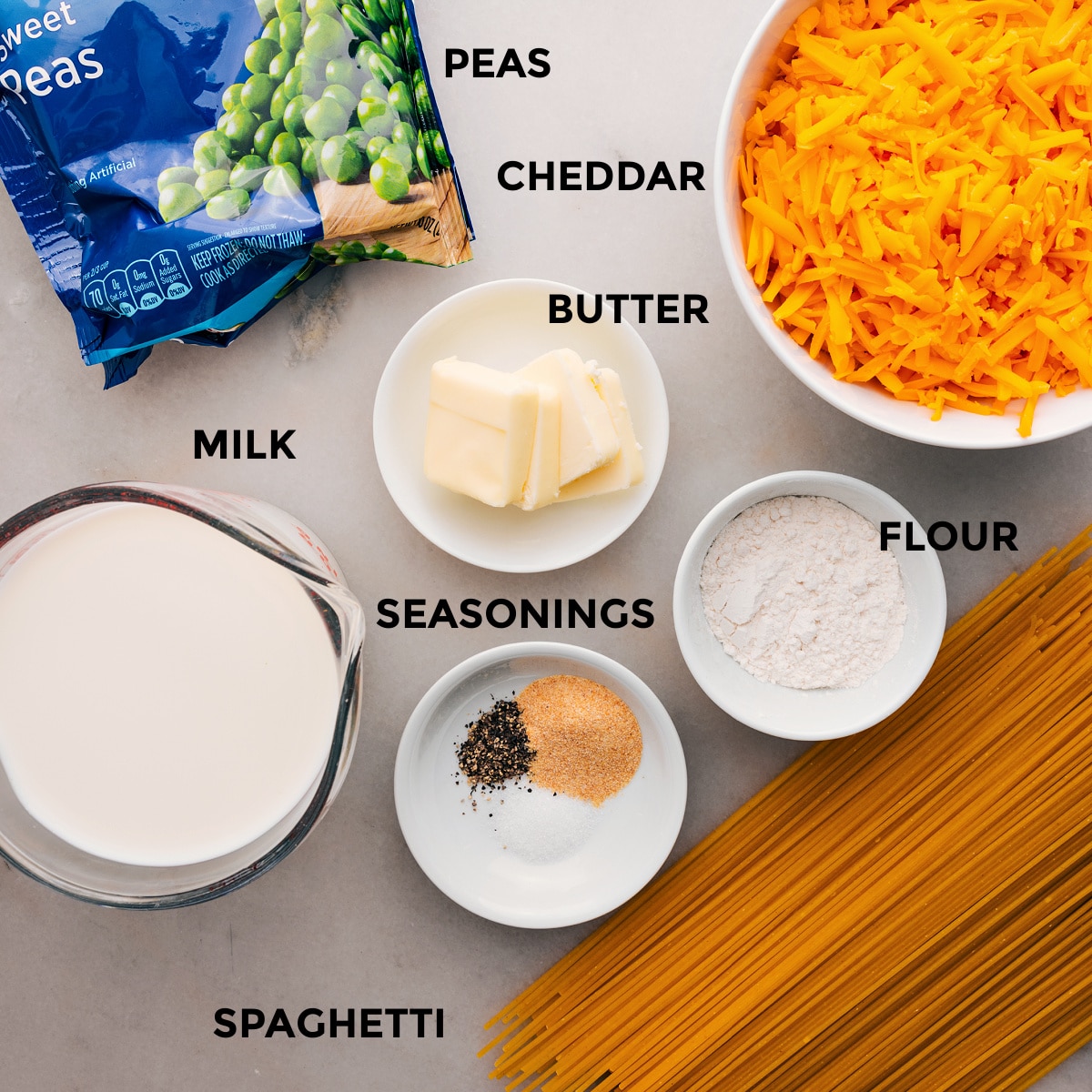 Ingredients In Cheesy Spaghetti This recipe's ingredients are prepped for easy assembly: pasta, flour, cheese, butter, peas, and milk.