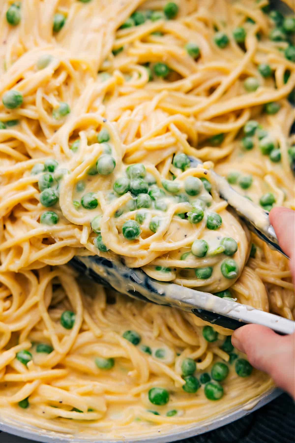 The Absolute Best Cheesy Spaghetti Recipe Cheesy spaghetti with peas, freshly made and ready to enjoy.