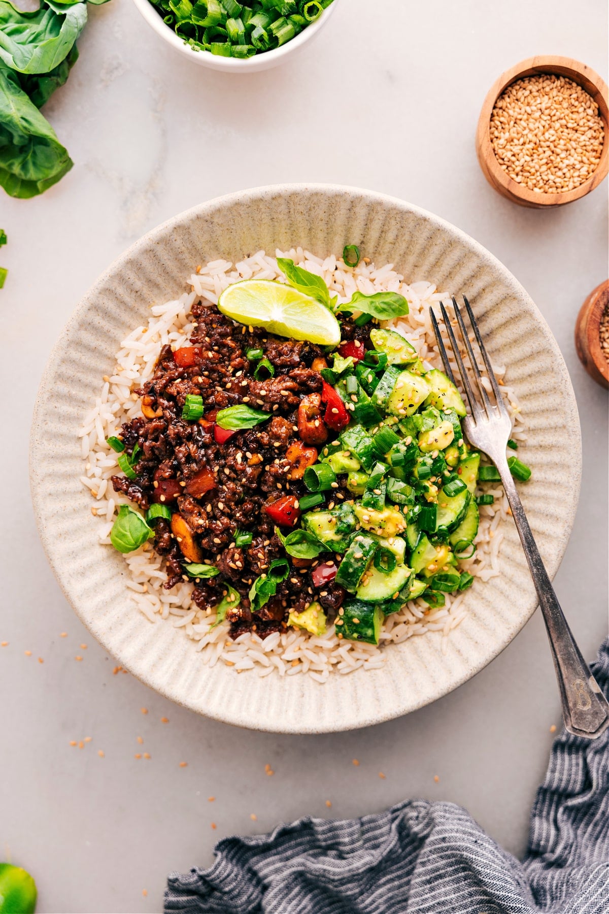 Asian Ground Beef On Rice With A Cucumber Salad On The Side The Asian ground beef dish plated on a bed of rice, with a cucumber avocado salad on the side.