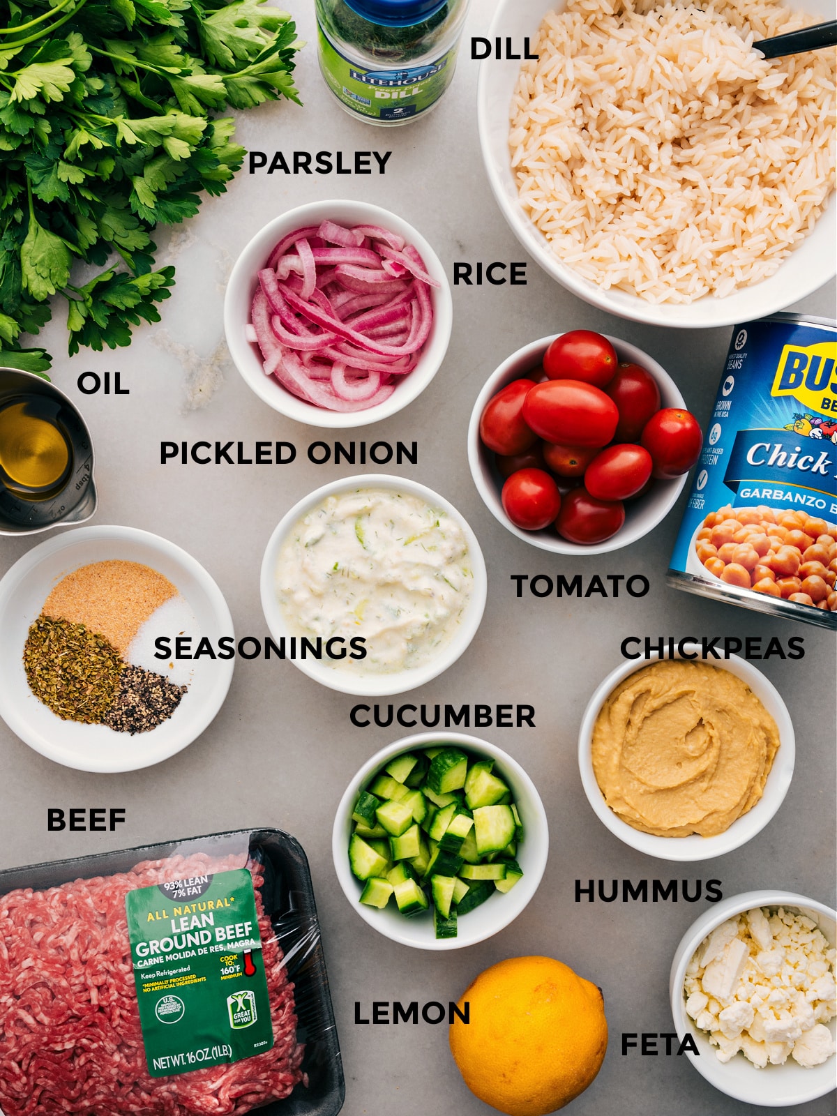 Ingredients In Greek Beef Bowl Recipe All the ingredients in this recipe are prepped for easy assembly: red onions, chickpeas, rice, veggies, seasonings, hummus, parsley, feta, lemon, and meat.