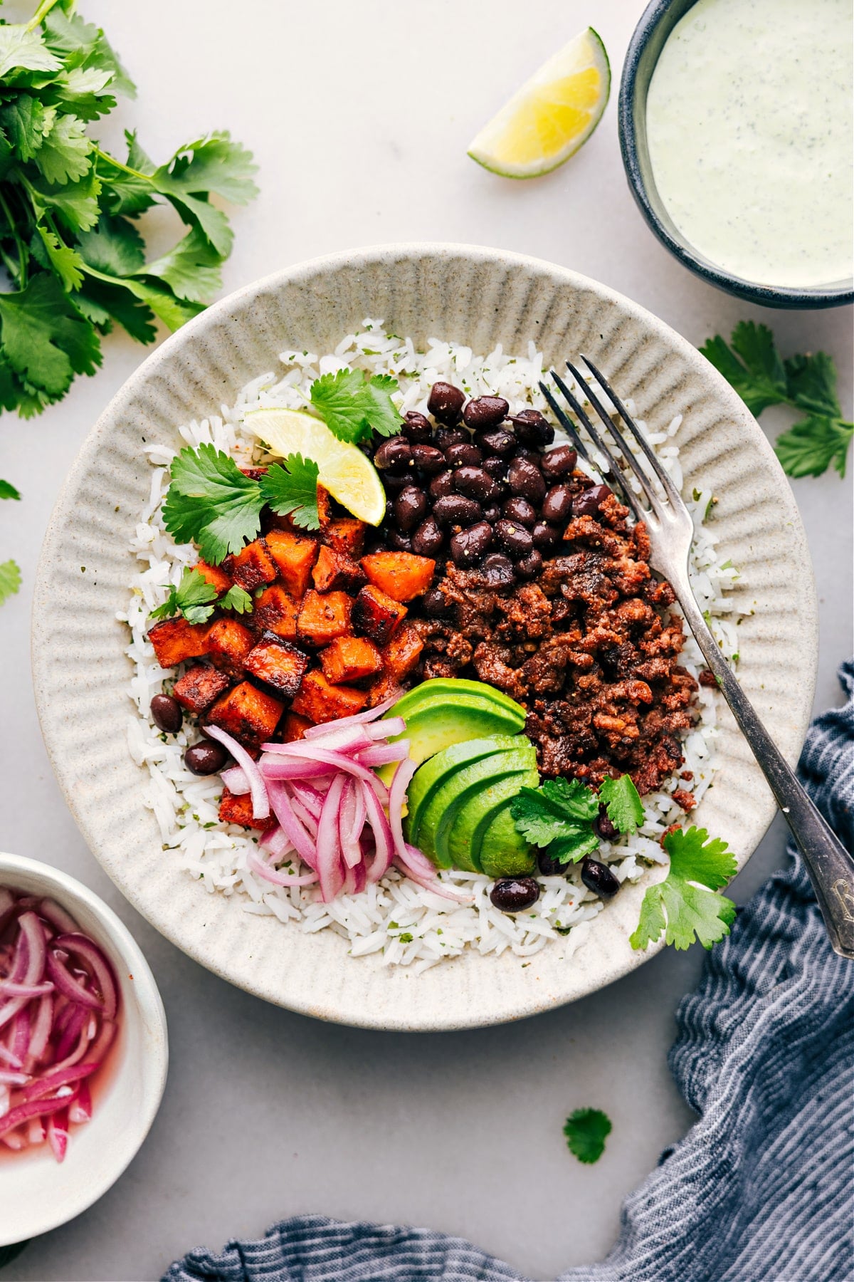 The Best Beef Burrito Bowl Recipe Beef Burrito Bowl with rice, avocado, red onions, and cilantro.