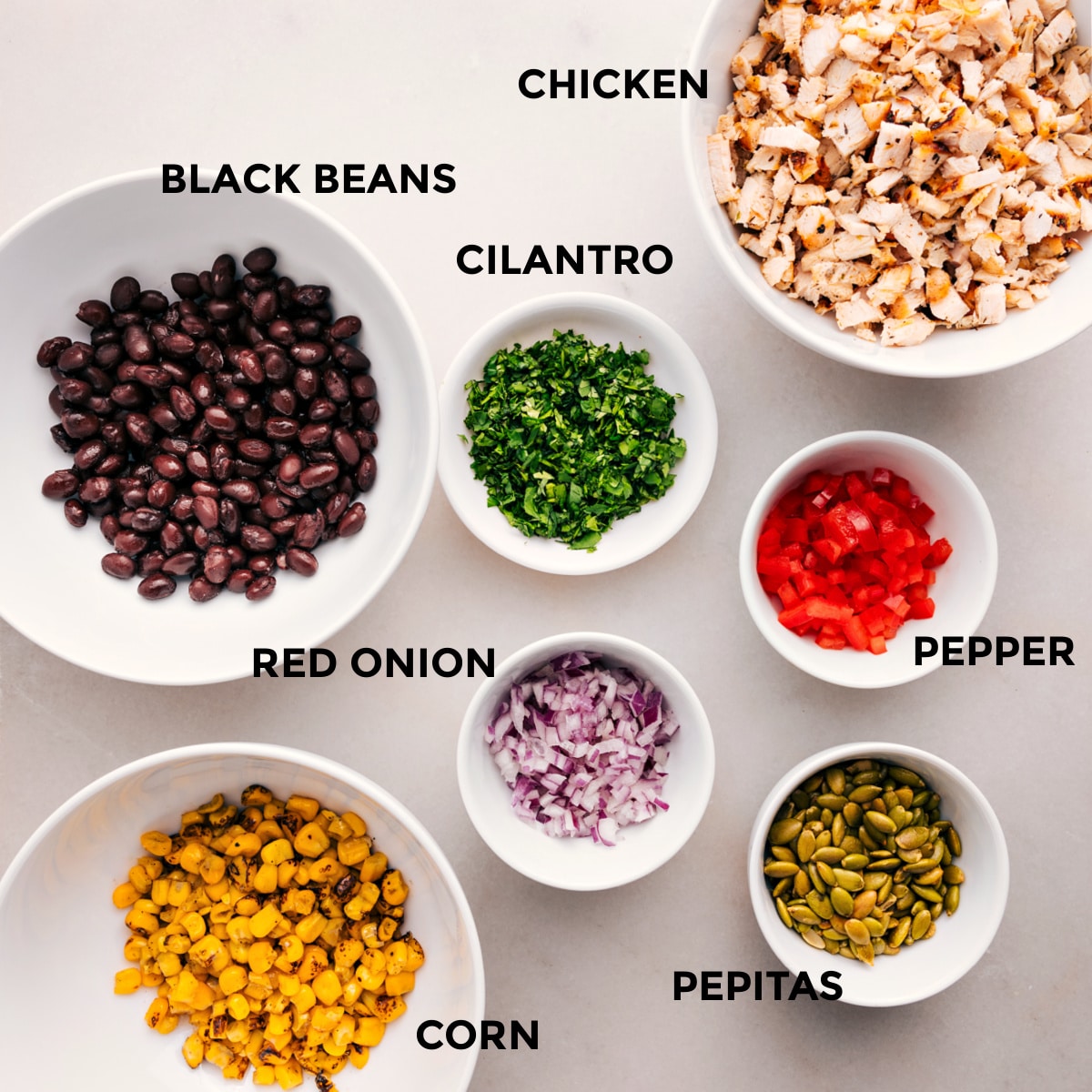 Ingredients Prepped And Ready For Southwest Chicken Salad All the ingredients in this recipe are prepped for easy assembly: meat, peppers, cilantro, black beans, red onion, pepitas, and corn.