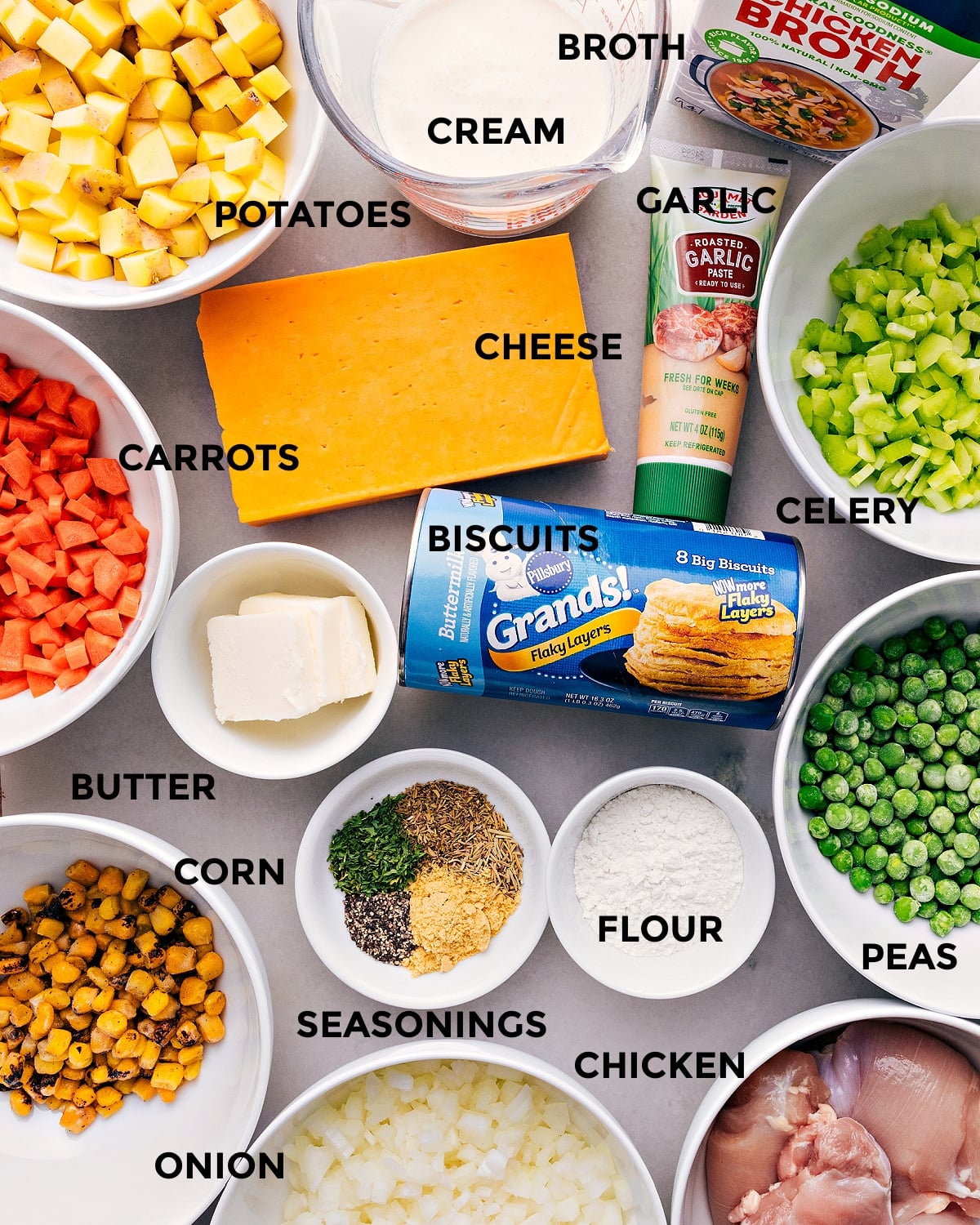 Ingredients In Crockpot Chicken Pot Pie Crockpot Chicken Pot Pie ingredients are prepped for easy assembly, including cheese, celery, veggies, biscuits, flour, meat, broth, and cream.