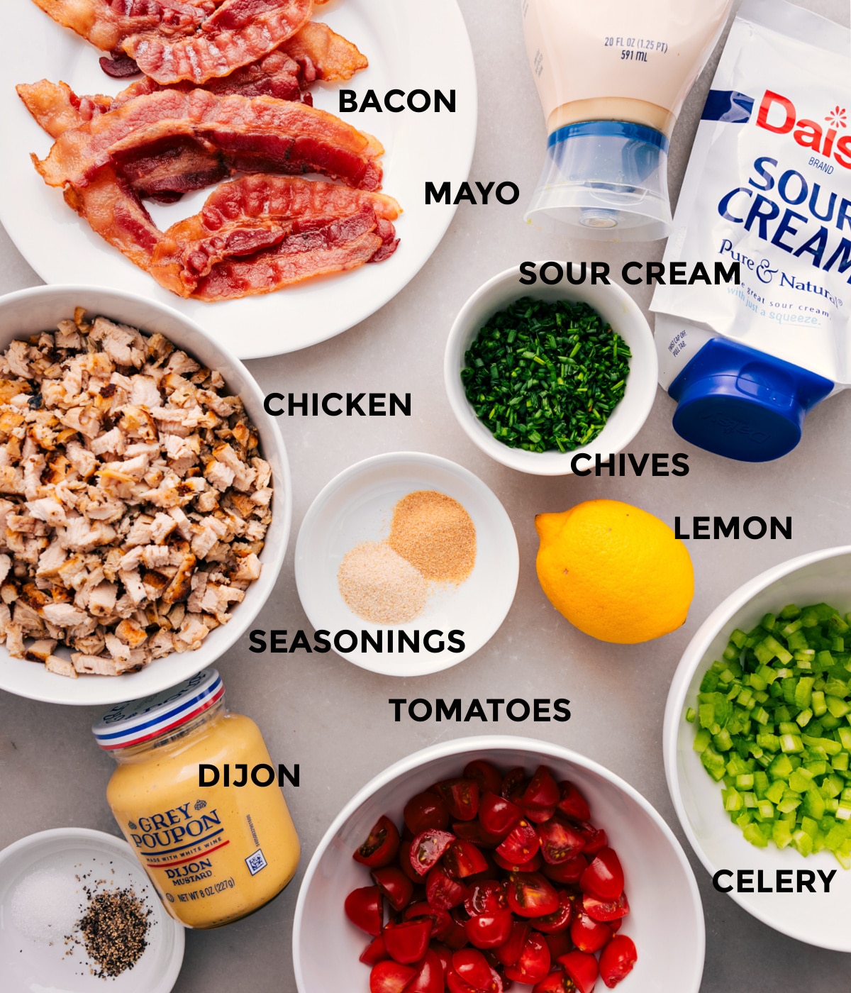 Ingredients In BLT Chicken Salad All the ingredients for this recipe are prepped and ready for easy assembly, including the meat, mayo, sour cream, chives, seasonings, lemon, celery, tomatoes, and Dijon.