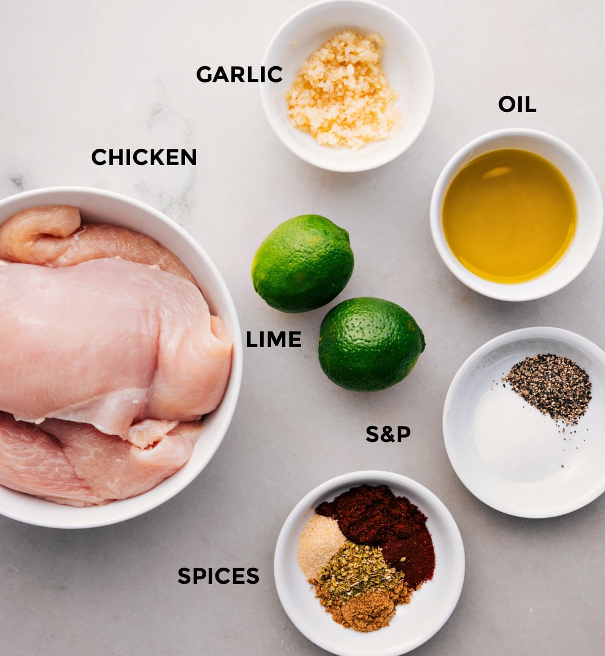 Ingredients In Chicken Taco Marinade All the ingredients prepped for easy assembly, including oil, spices, lime, garlic, and chicken.