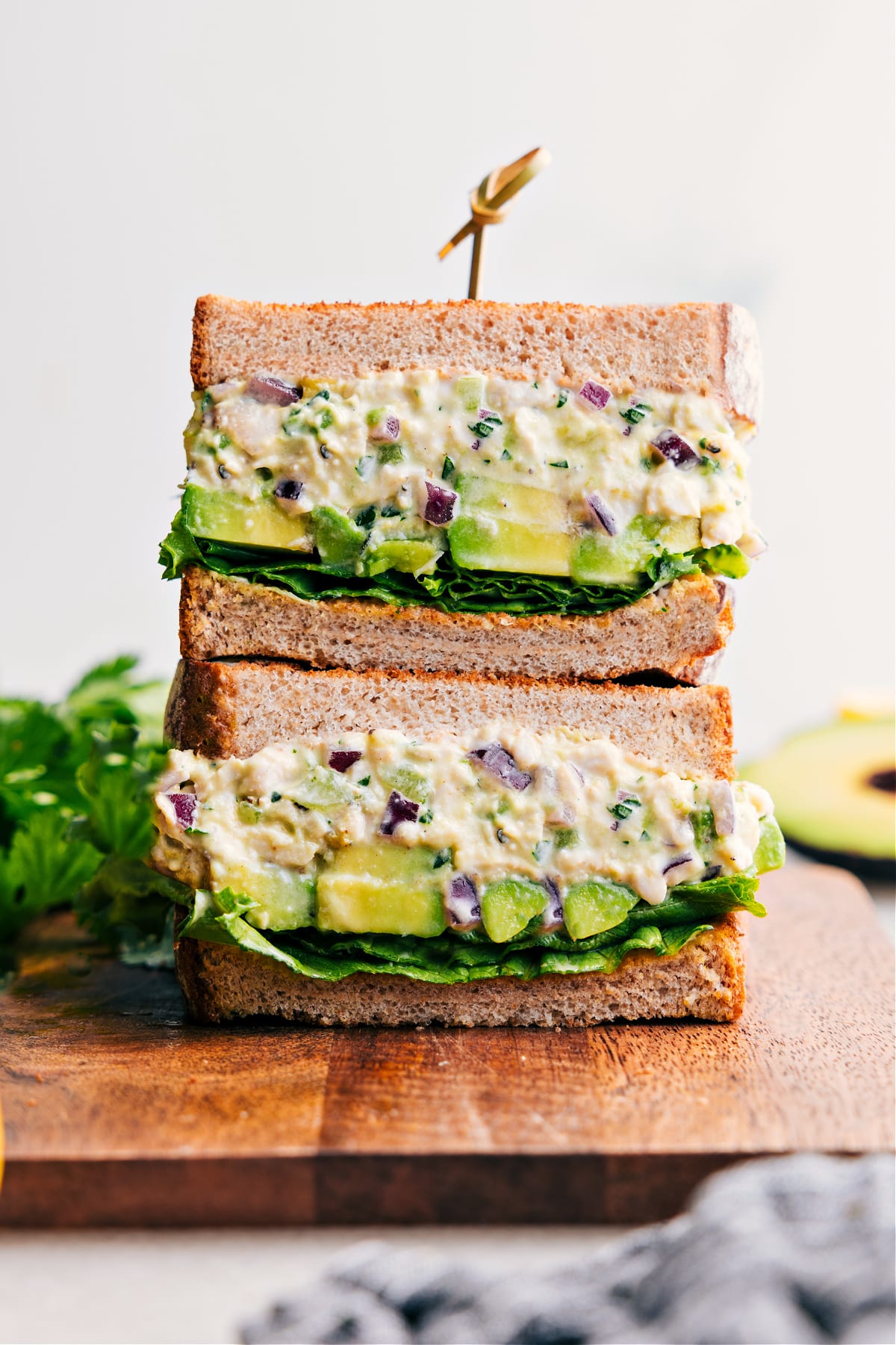 The Ultimate Chicken Avocado Sandwich Recipe Chicken Avocado Sandwich, sliced in half and stacked to show off the delicious filling.