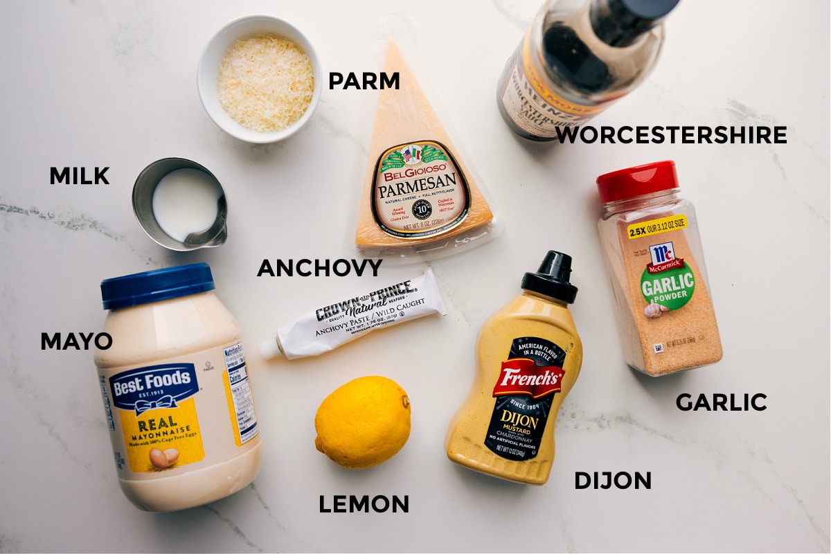 Ingredients For This Caesar Dressing Recipe All the ingredients in this recipe prpped out for easy assembly including the parm, worcestershire, anchovy, lemon, dijon, garlic powder, milk, and mayo.