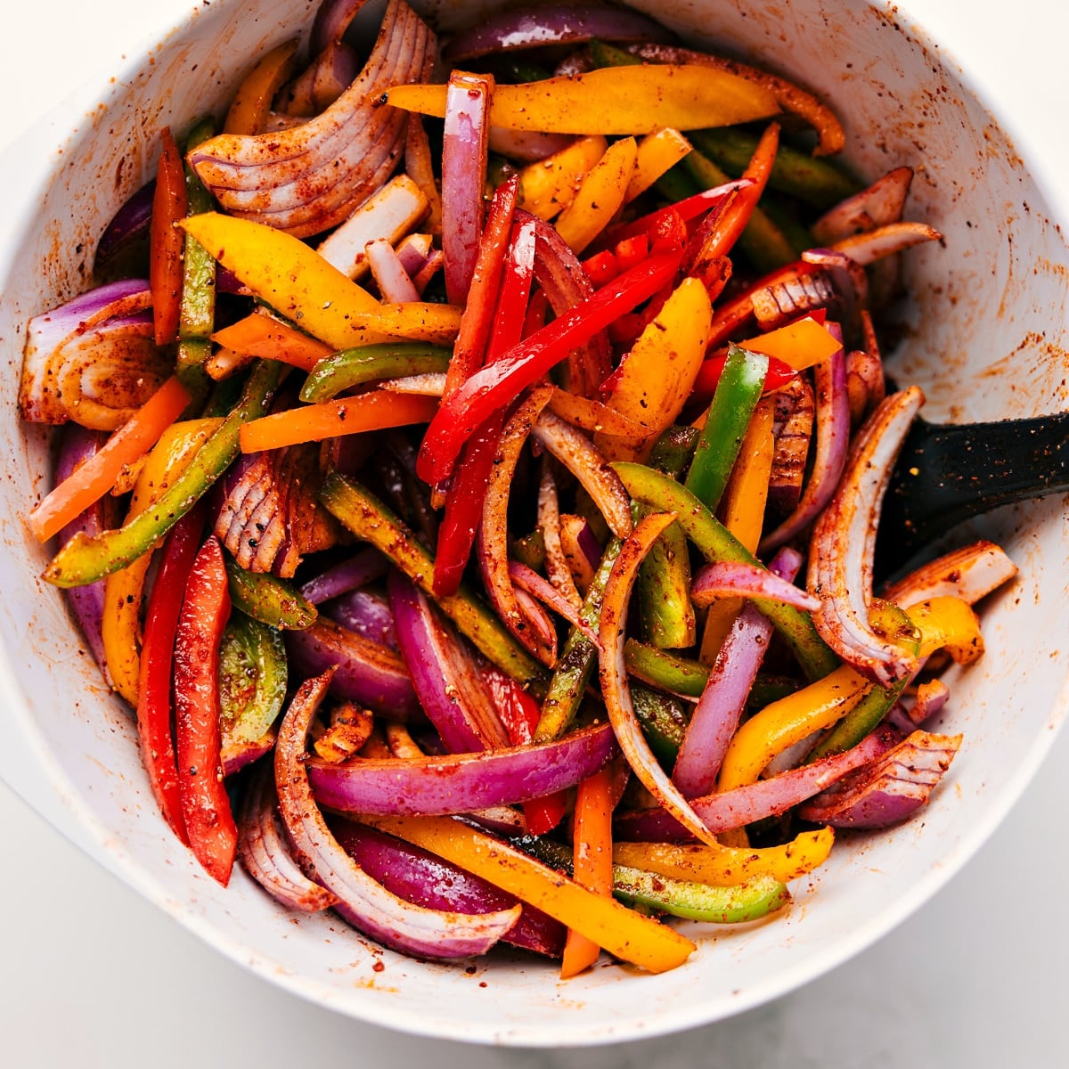 How To Make Sheet Pan Chicken Fajitas All the veggies chopped and tossed with the seasoning mix in a bowl for these sheet pan chicken fajitas.