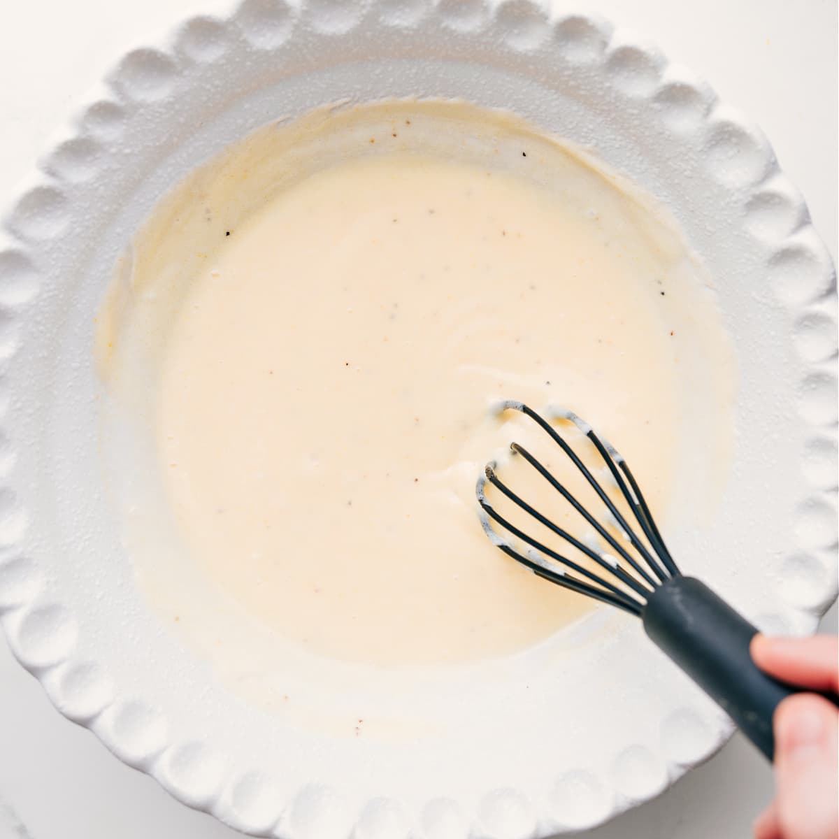 The Best Dressing In A Coleslaw The Chick-Fil-A coleslaw dressing being whisked together in the bottom of a bowl.