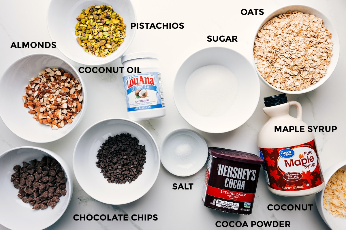 Ingredients Chocolate Granola Recipe All the ingredients for this recipe laid out for easy assembly—oats, sugar, maple syrup, cocoa powder, salt, chocolate chips, coconut oil, pistachios, and almonds.