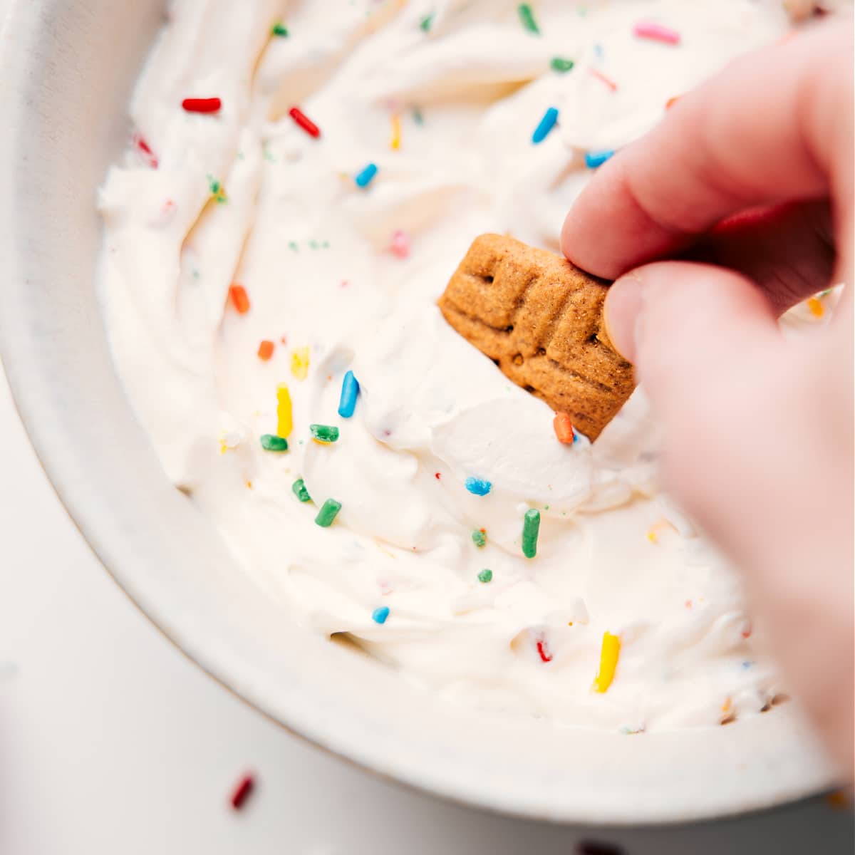 Funfetti Inspired High Protein Fluffy Yogurt Funfetti-flavored fluffy yogurt in a bowl with a graham cracker dipped into it.