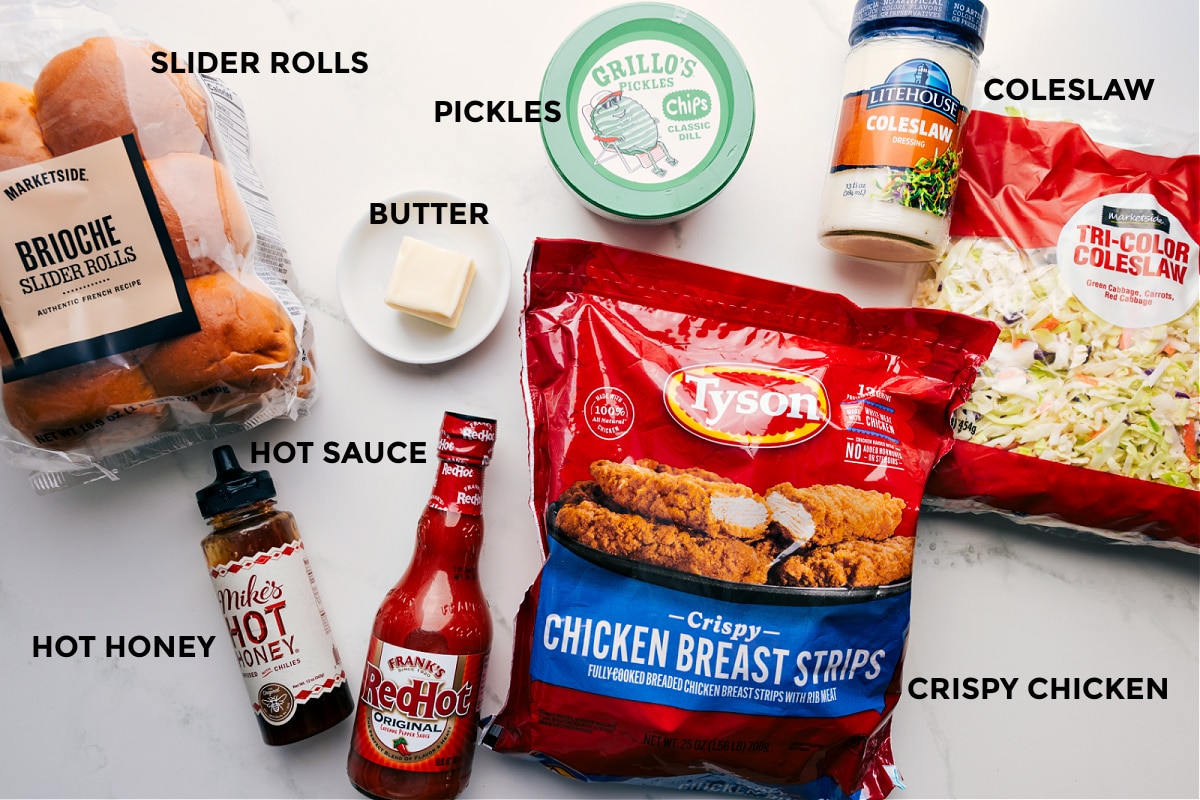 Ingredients In Hot Honey Chicken Sliders Ingredients prepped for Hot Honey Chicken Sliders: rolls, honey, hot sauce, butter, pickles, coleslaw, crispy chicken, and dressing.