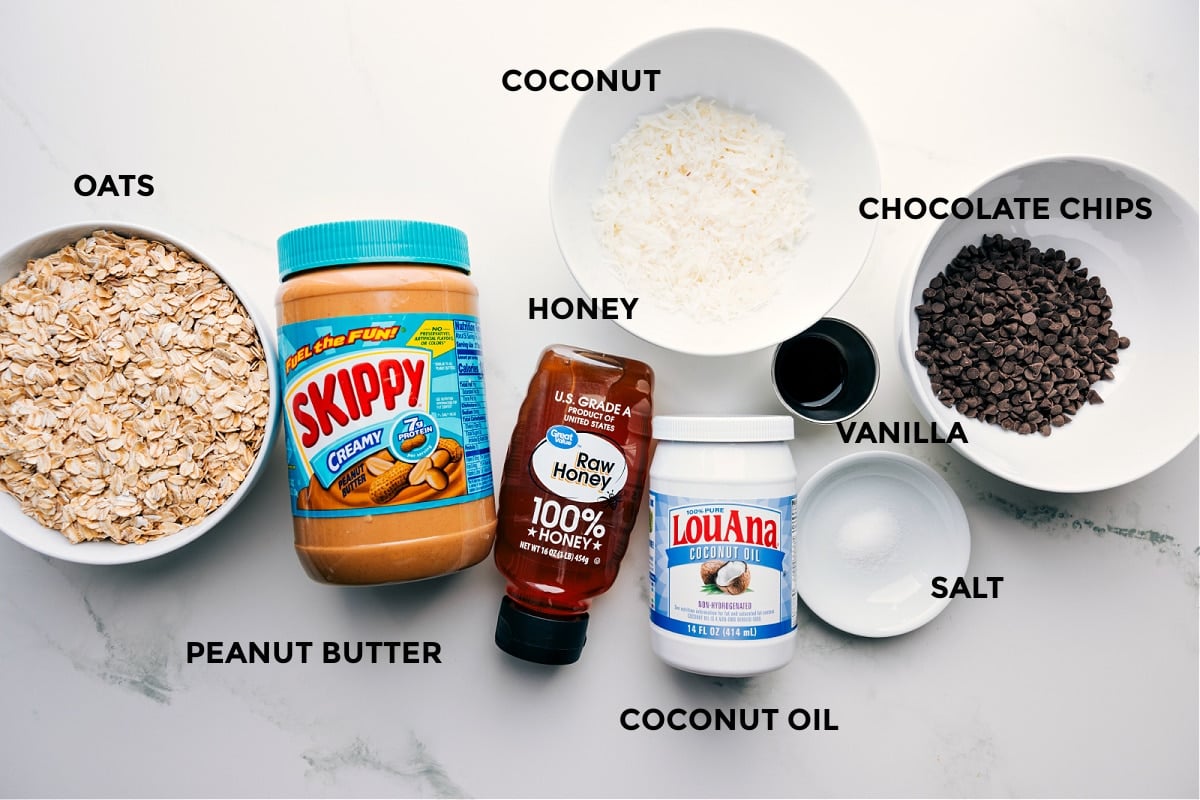 Ingredients In Peanut Butter Granola Recipe Prepped ingredients for Peanut Butter Granola including oats, peanut butter, coconut, honey, coconut oil, vanilla, salt, and chocolate chips.