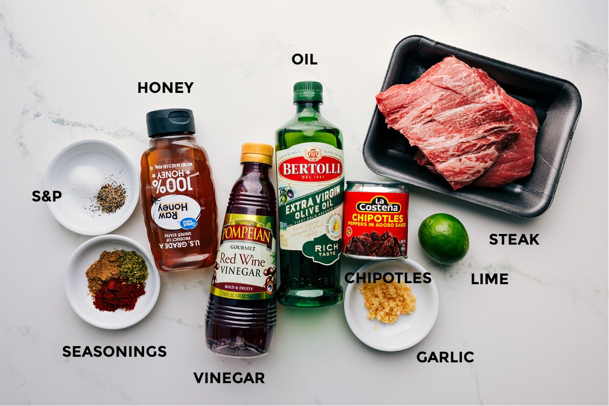 Ingredients In This Burrito Bowl Steak Marinade Marinade ingredients laid out for steak including spices, honey, vinegar, oil, chipotles, lime, and garlic.