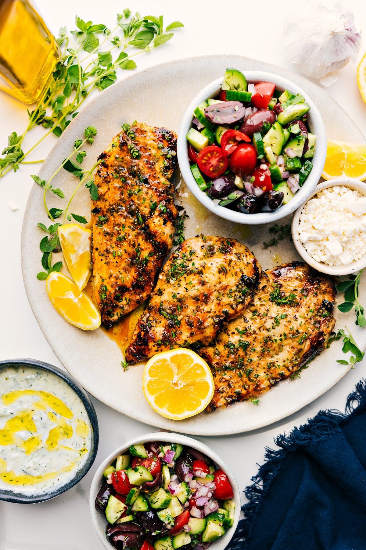 Fresh And Flavorful Greek Chicken Marinade Greek Chicken Marinade served on a platter with Greek salad, feta, and lemon slices.