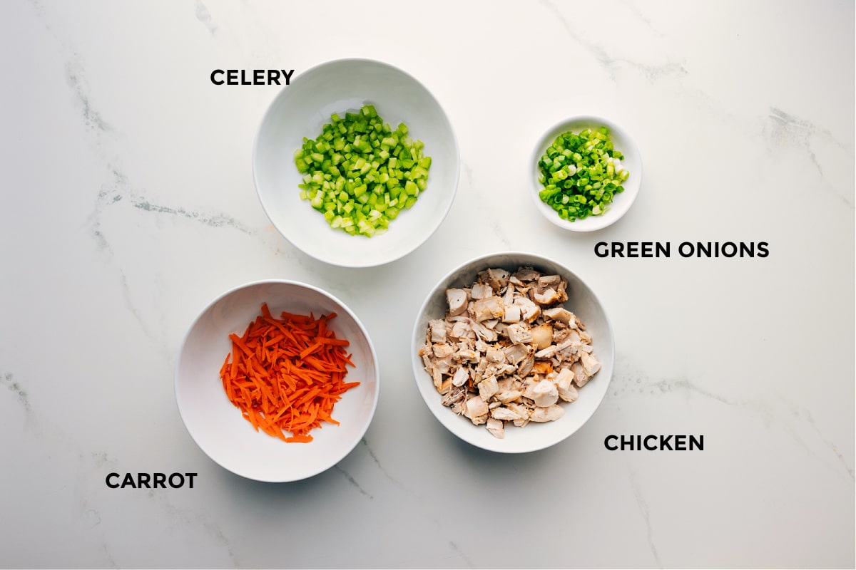 Ingredients In Hot Honey Chicken Salad Ingredients prepped out for easy assembly including celery, carrot, green onions, and chicken.