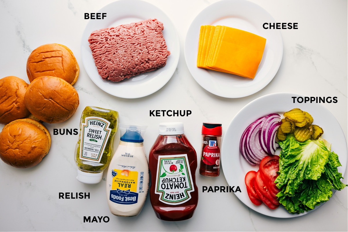 Ingredients In Smashburger Recipe Ingredients prepped out for easy assembly including the buns, beef, relish, mayo, ketchup, paprika, cheese, and toppings.