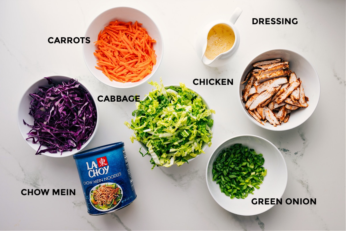 Ingredients In Asian Chicken Salad All the ingredients in this recipe prepped out for easy assembly including the cabbage, carrots, chow mein, chicken, dressing, and green onions.