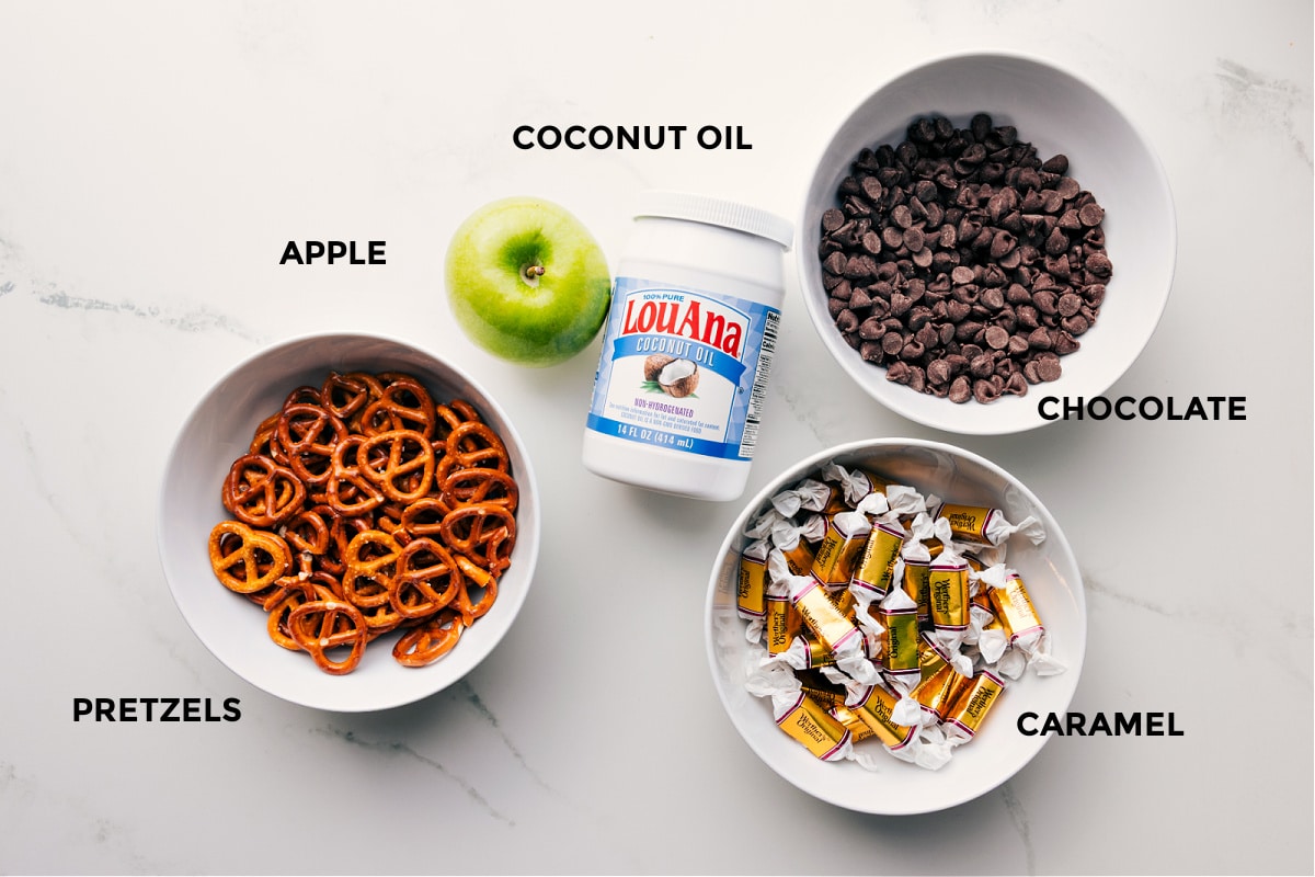 Ingredients In Caramel Apple Bark Ingredients in this recipe prepped out for easy assembly including the pretzels, apple, coconut oil, chocolate, and caramel.