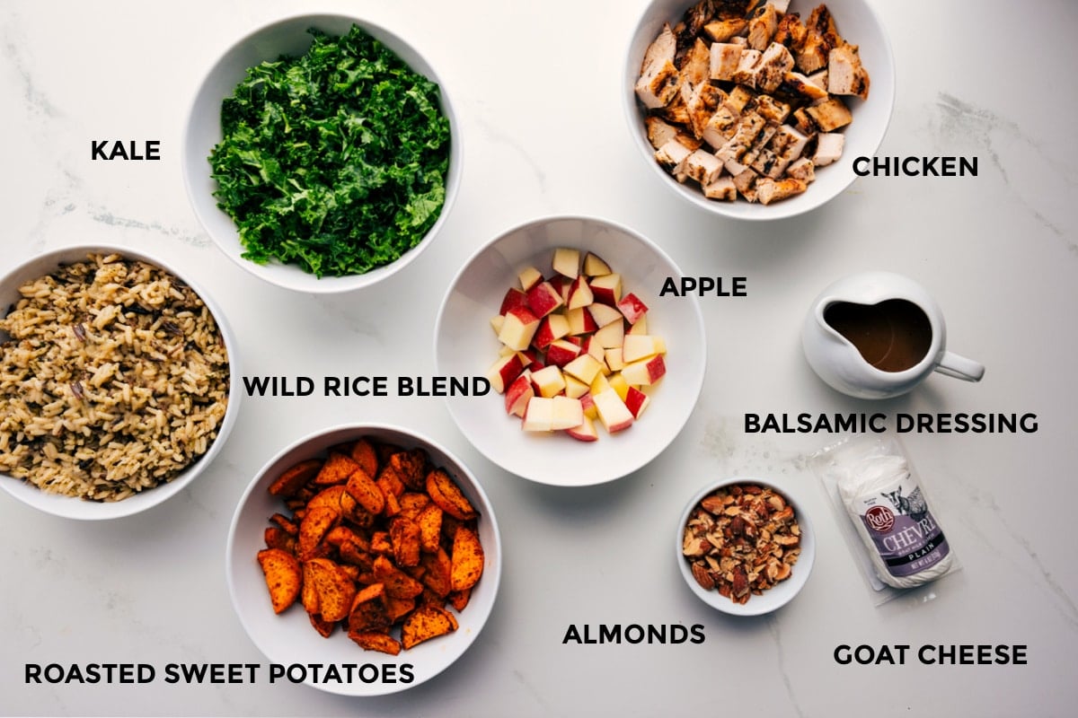 Ingredients In Chicken Sweet Potato Recipe All the ingredients prepped out for easy assembly including the wild rice blend, kale, roasted sweet potatoes, apples, chicken, balsamic dressing, almonds, and goat cheese.