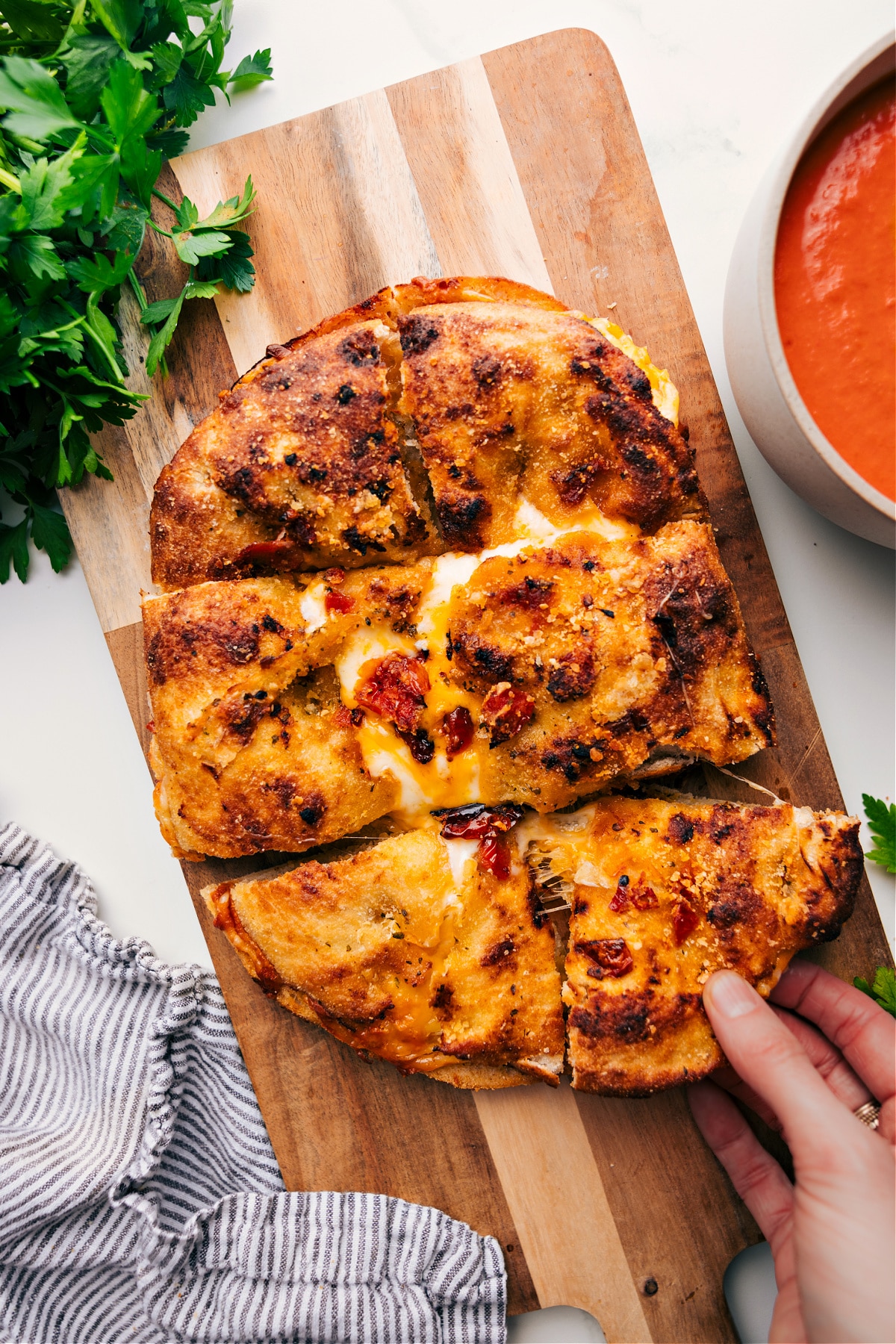 Focaccia Grilled Cheese with a gooey, cheesy square being pulled out.