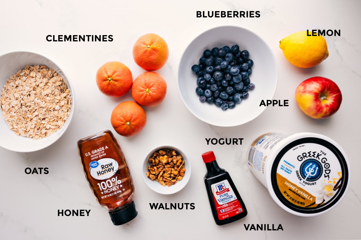 Ingredients In Princess Diana's Breakfast Ingredients in this recipe prepped out for easy assembly including the oats, honey, walnuts, clementines, blueberries, yogurt, vanilla, lemon, and apple.