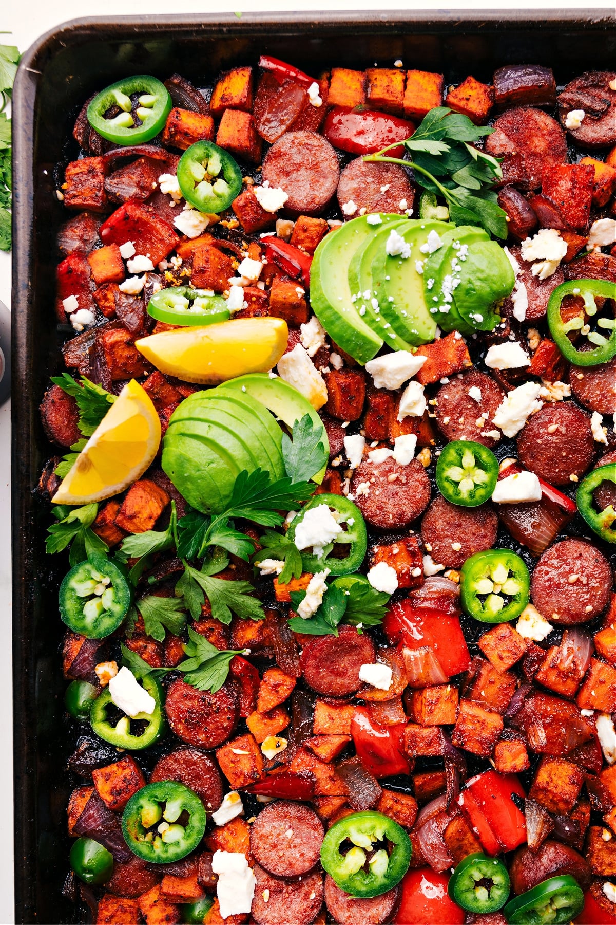 Sheet pan hot honey sausage and veggies, fresh from the oven, sprinkled with feta.