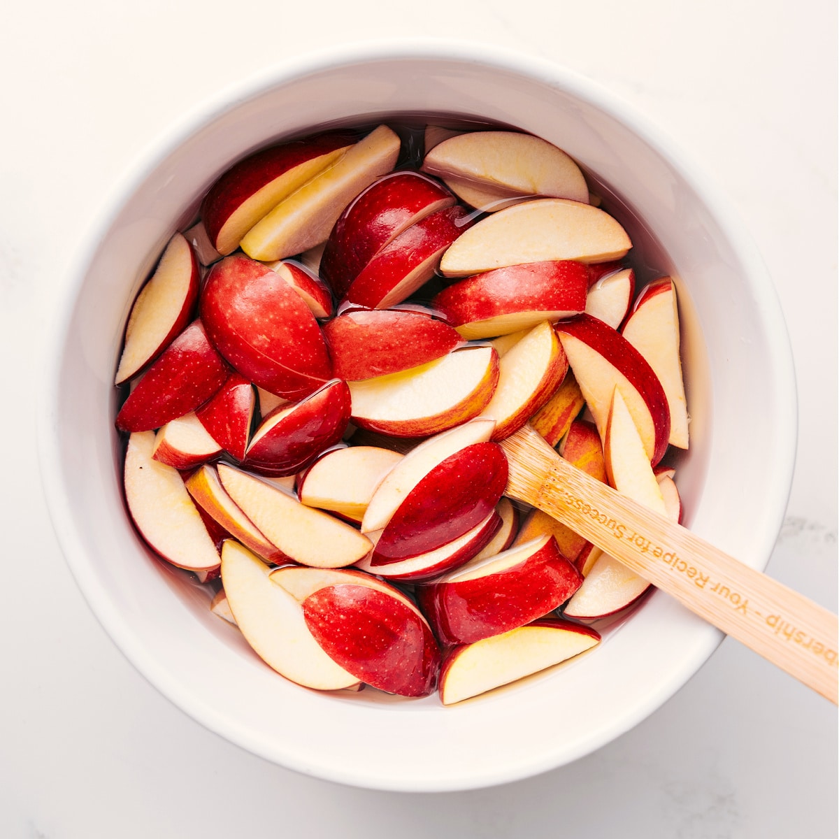 How To Make Caramel Apple Dessert Cups Apple slices soaking in salted water to prevent browning for Caramel Apple Dessert Cups.
