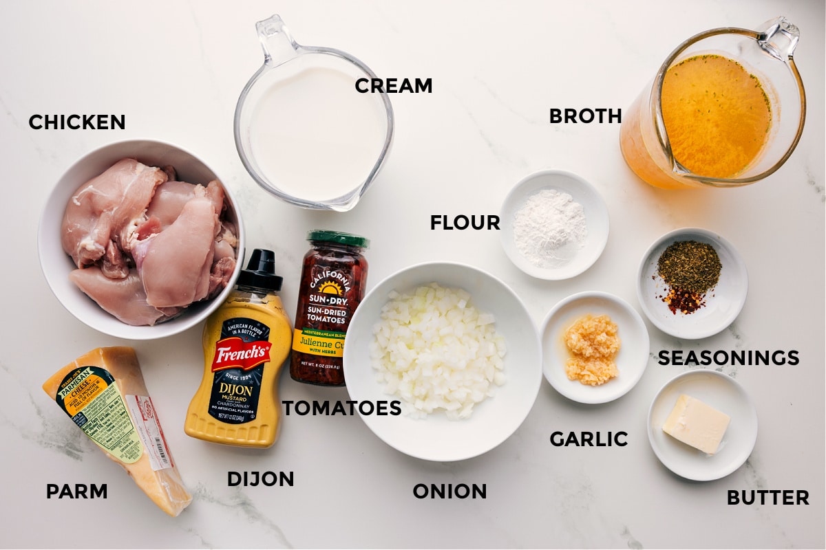 Ingredients In Crockpot Marry Me Chicken Recipe All the ingredients prepped for easy assembly, including chicken, Parmesan, Dijon, cream, tomatoes, onion, flour, garlic, seasonings, butter, and broth.