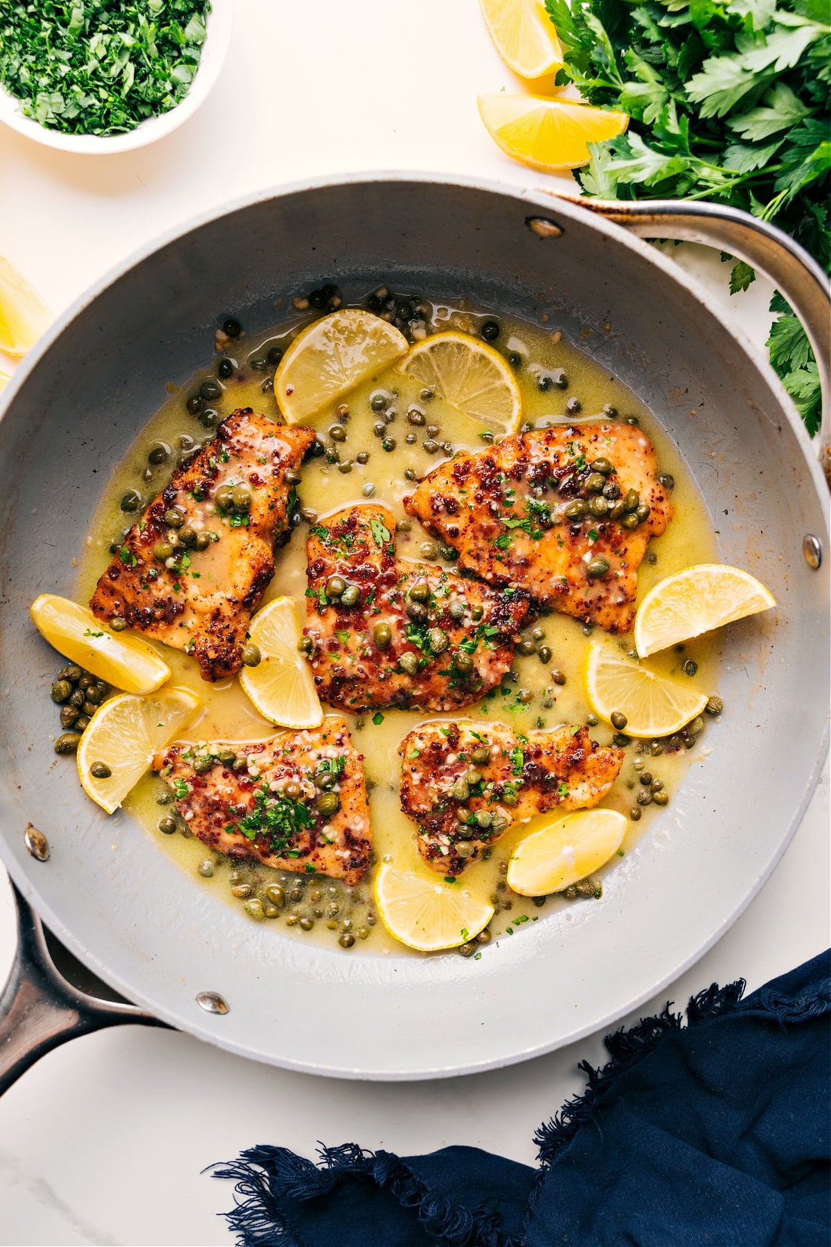 One skillet Chicken Piccata Recipe Chicken Piccata in the skillet ready to be enjoyed with fresh lemons.