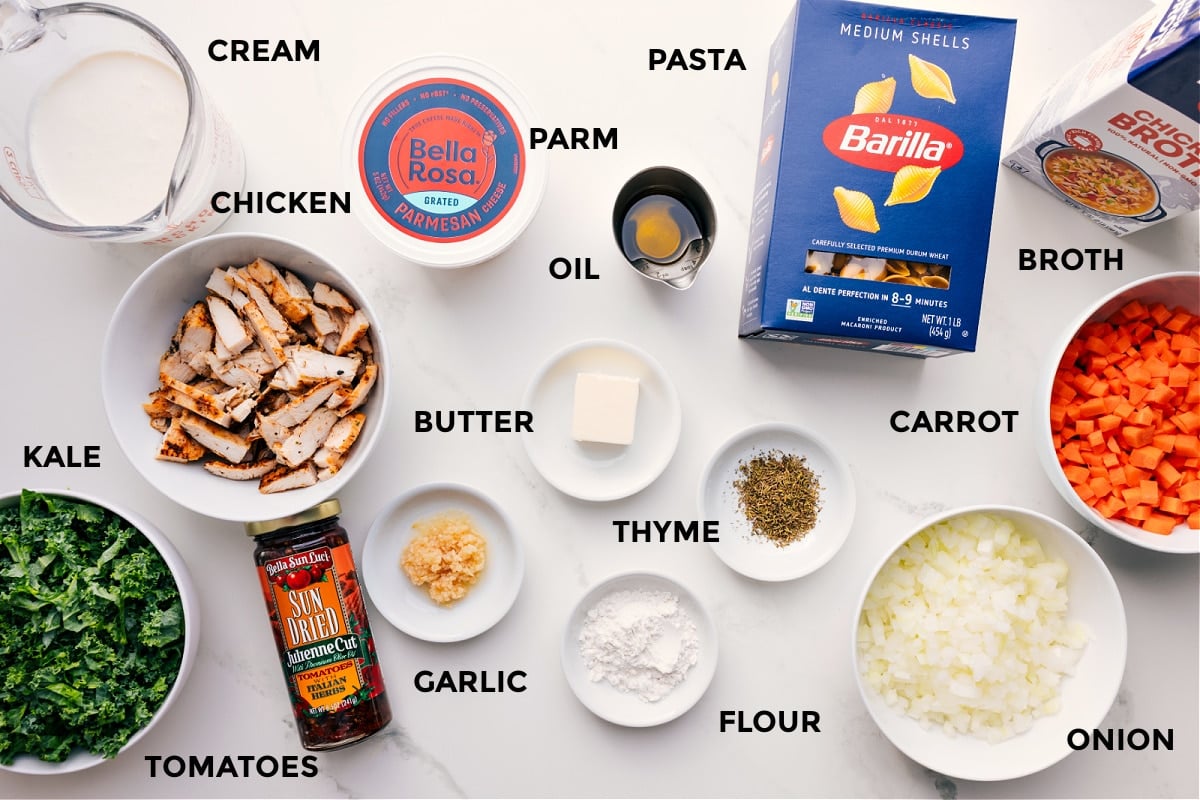 Ingredients In Marry Me Chicken Soup All the ingredients prepped and ready to assemble, including cream, chicken, kale, tomatoes, garlic, Parmesan, oil, butter, flour, thyme, pasta, carrot, onion, and broth.