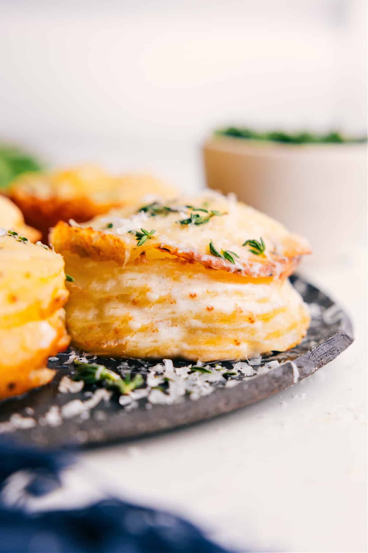 Potato stacks recipe fresh from the oven topped with melted cheese and thyme.