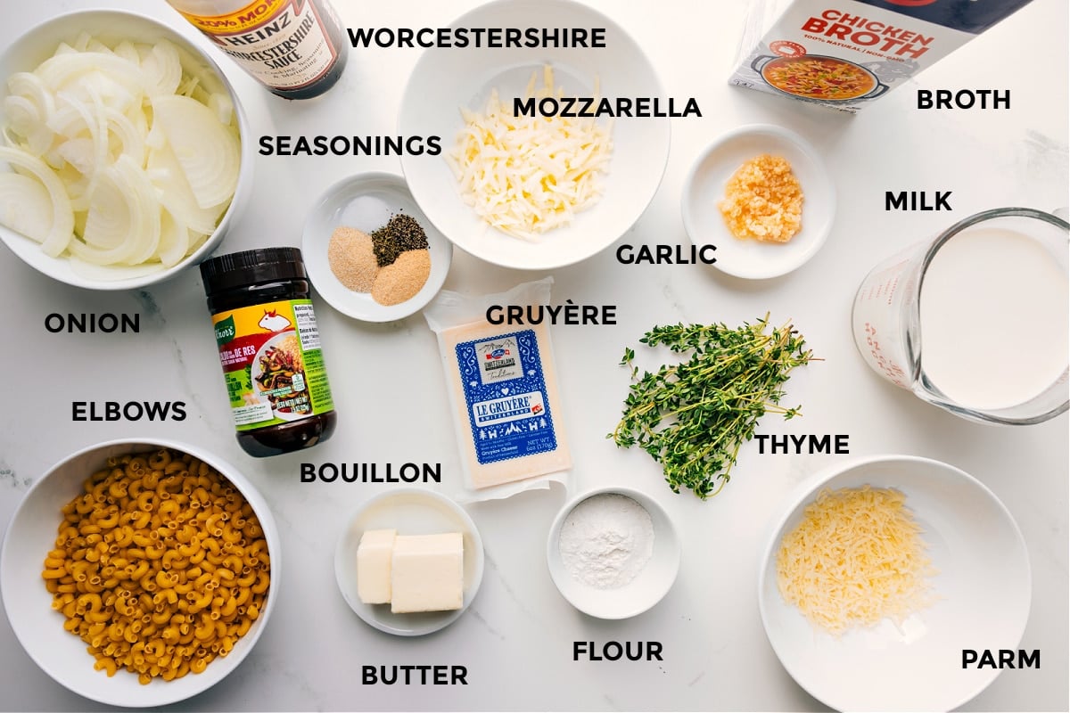 Ingredients In French Onion Mac And Cheese Prepped ingredients on the counter: onions, elbow macaroni, Worcestershire sauce, bouillon, butter, mozzarella, garlic, Gruyรจre, flour, thyme, Parmesan, milk, broth.