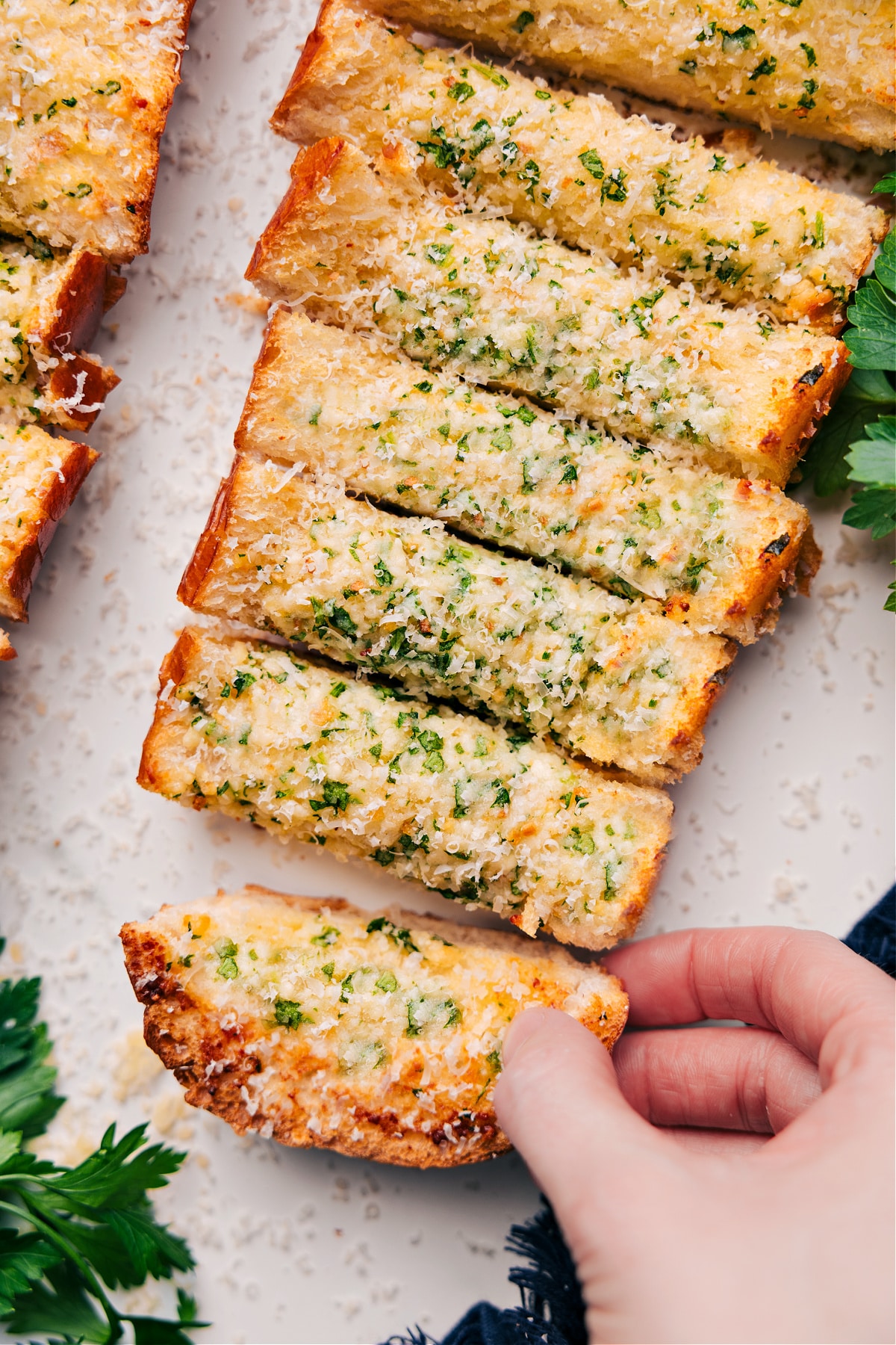 Comforting And Delicious Garlic Bread Recipe Garlic Bread Recipe cut into slices and topped with freshly grated Parmesan cheese, ready to serve.