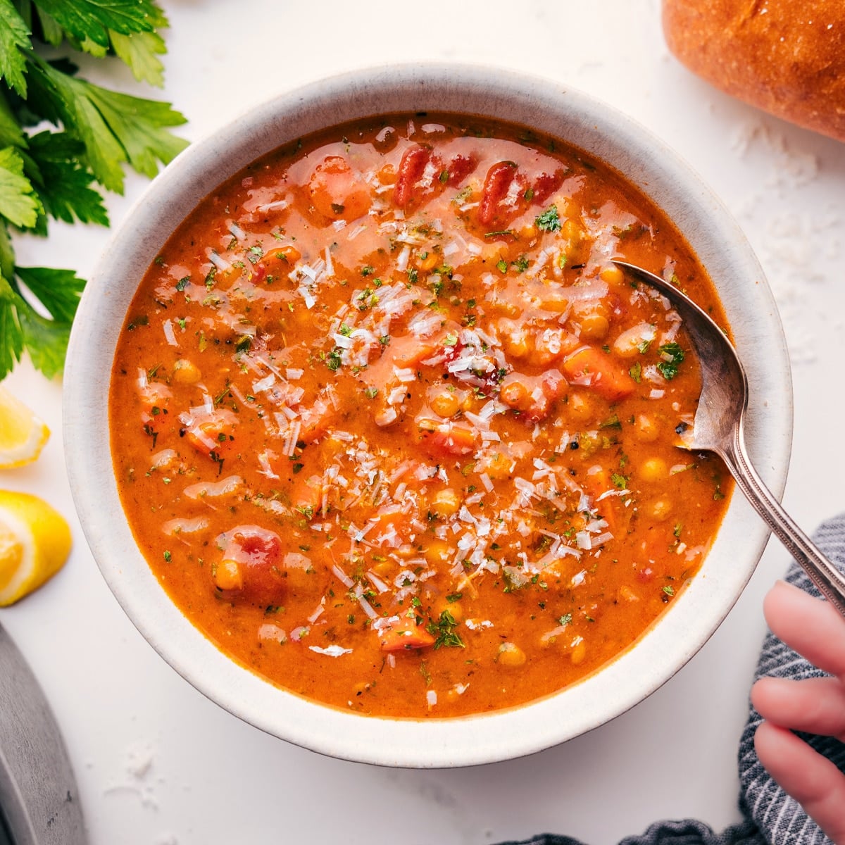 A Flavor Packed Lentil Soup That's Perfect For A Weeknight Dinner A bowl full of the flavorful and delicious soup with fresh parmesan grated on top.