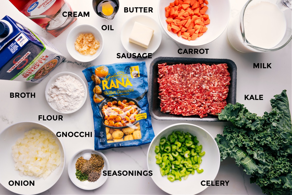 Ingredients In Sausage Gnocchi Soup All the ingredients in this recipe prepped out for easy assembly including the broth, cream, flour, onion, gnocchi, seasonings, celery, kale, milk, carrot, sausage, butter, and oil.