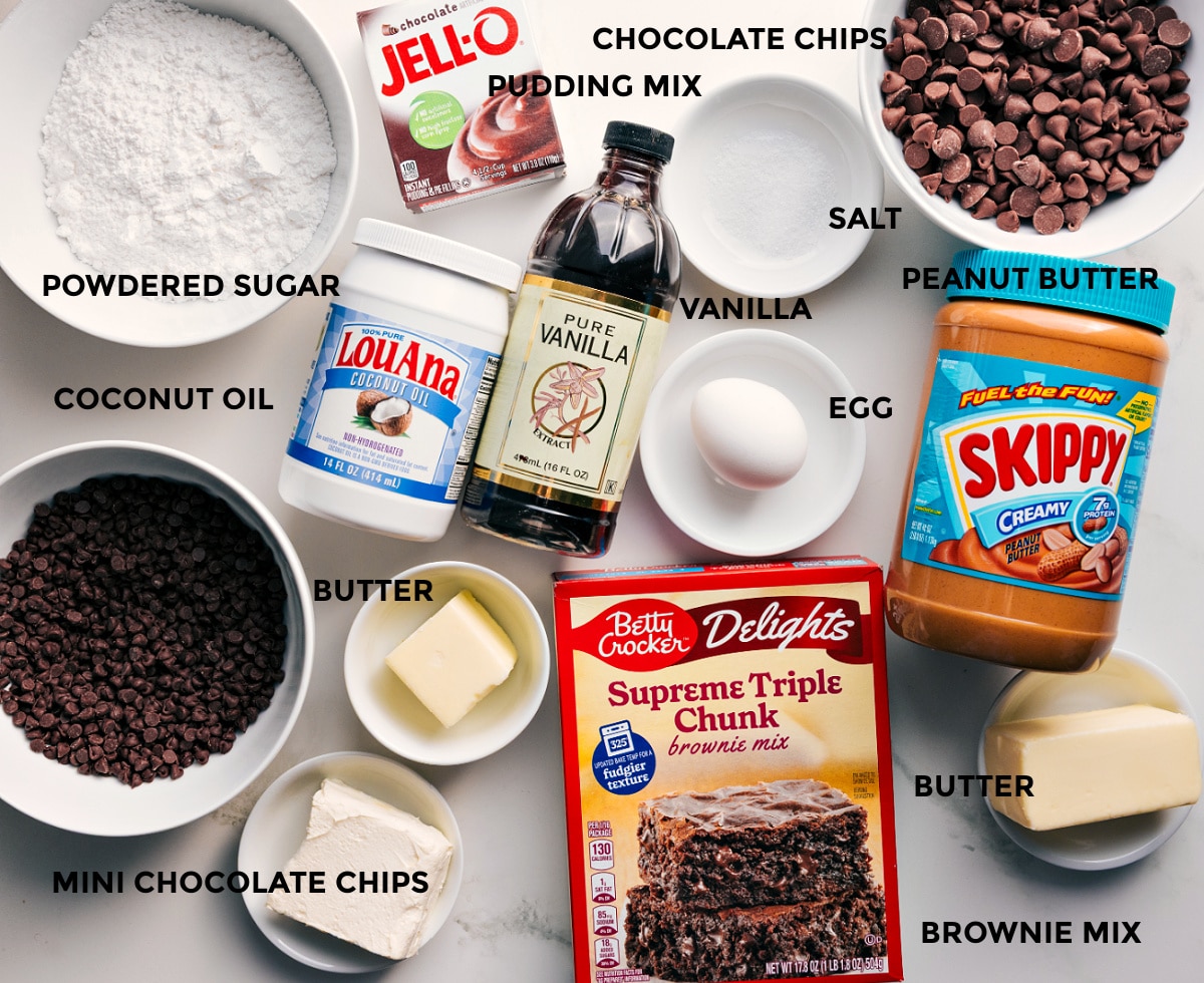 Ingredients In Buckeye Brownie Cookies All the ingredients in this recipe prepped out for easy assembly including the powdered sugar, coconut oil, chocolate chips, butter, vanilla, pudding mix, peanut butter, egg, and brownie mix.