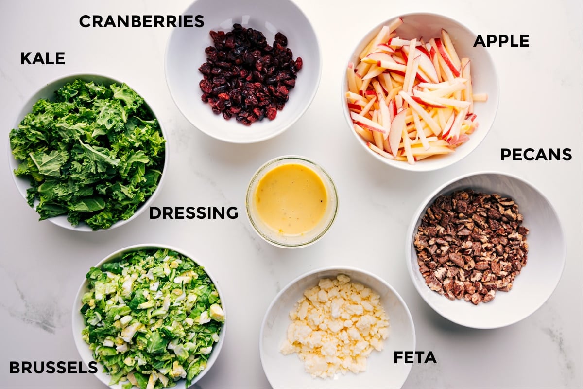 All the ingredients prepped out for easy assembly including the kale, Brussels, cranberries, dressing, feta, pecans, and apples.