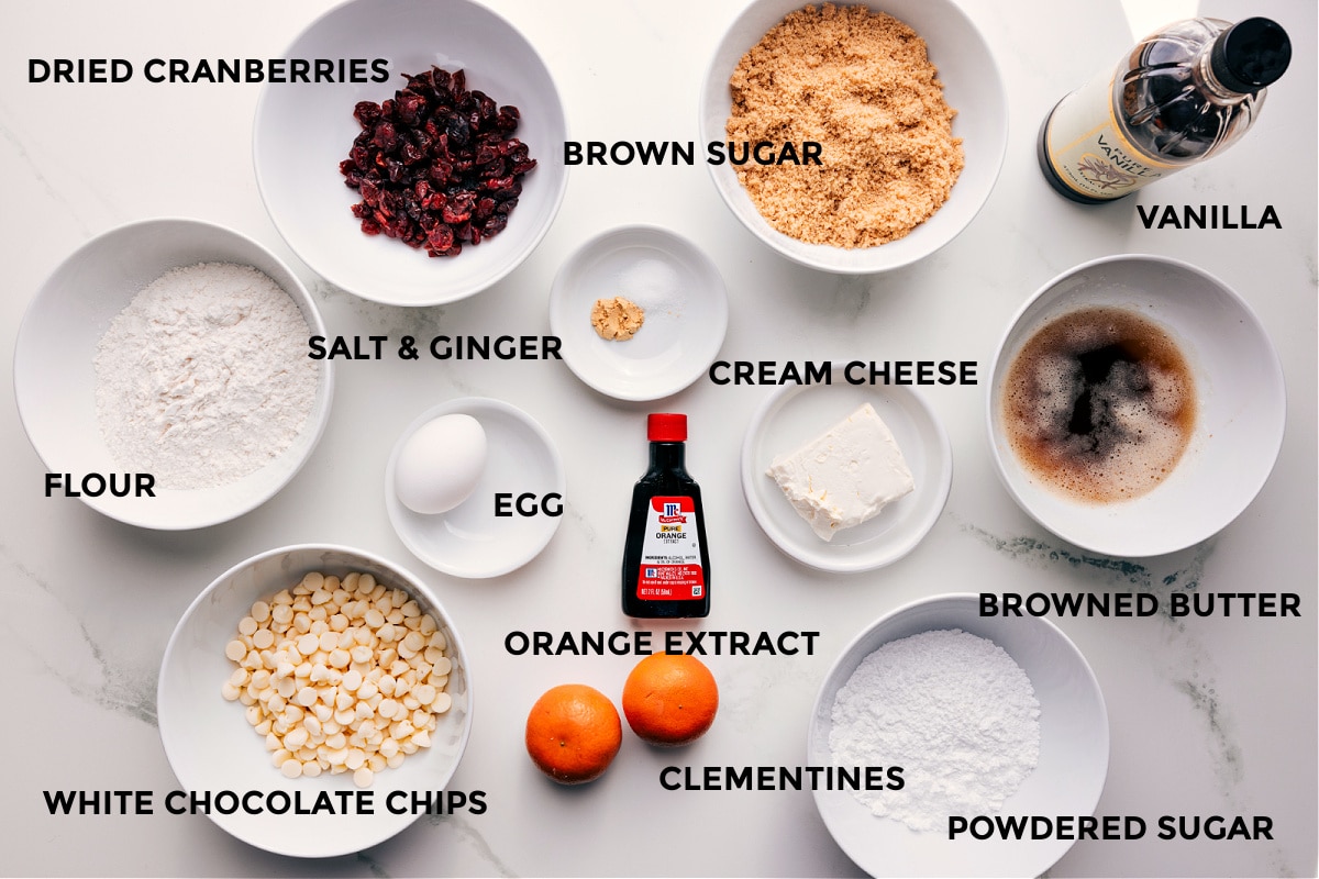 Ingredients In Cranberry Bliss Bars All the ingredients in this recipe prepped out for easy assembly including flour, cranberries, white chocolate chips, brown sugar, salt, ginger, egg, orange extract, clementines, cream cheese, powdered sugar, browned butter, and vanilla.