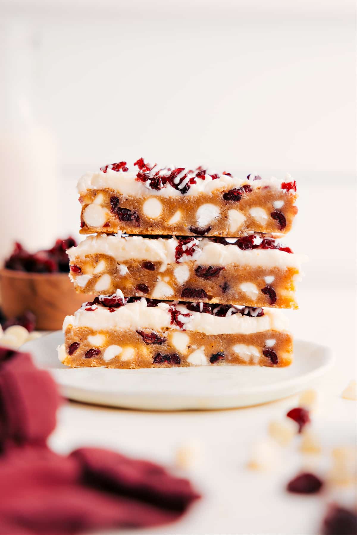 Cranberry Bliss Bars stacked on top of each other showing the layers of cranberries and white chocolate chips.