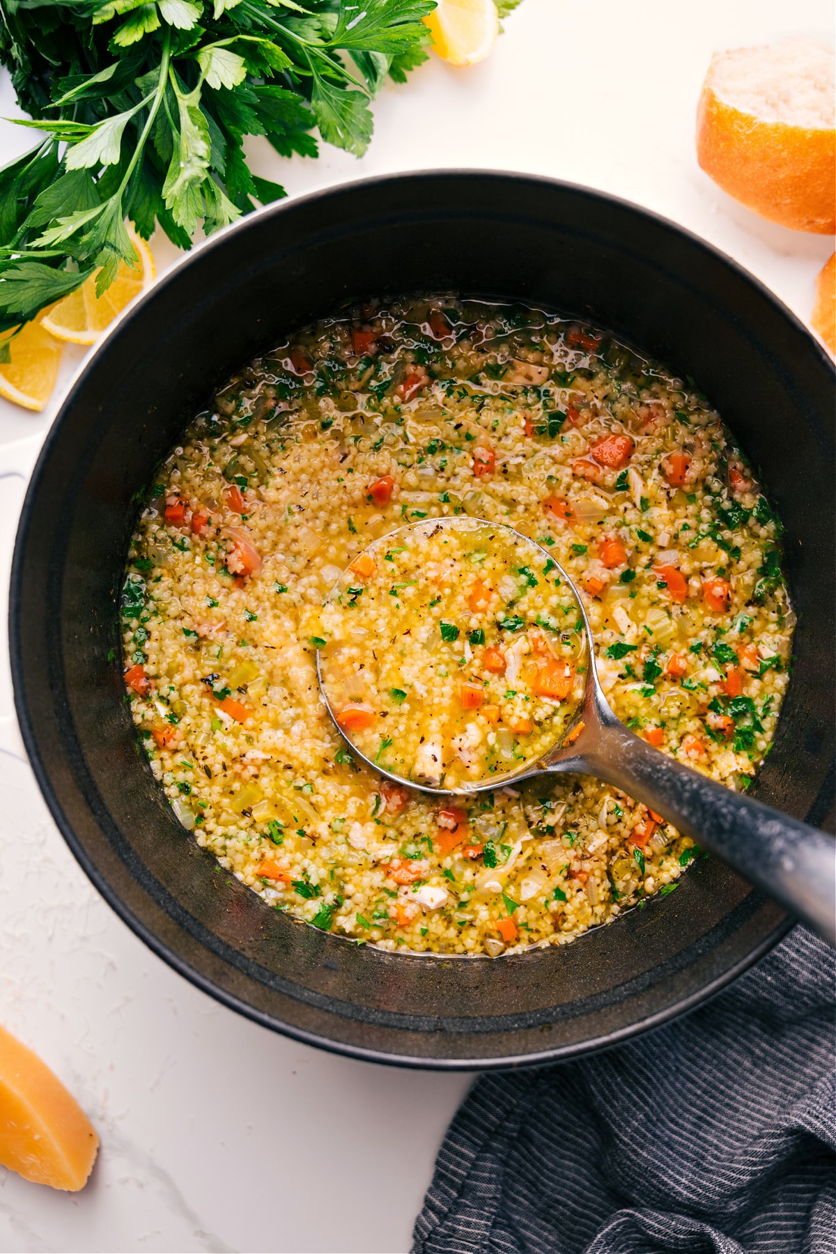 Pastina Soup in a pot with a big ladle full coming out to serve.