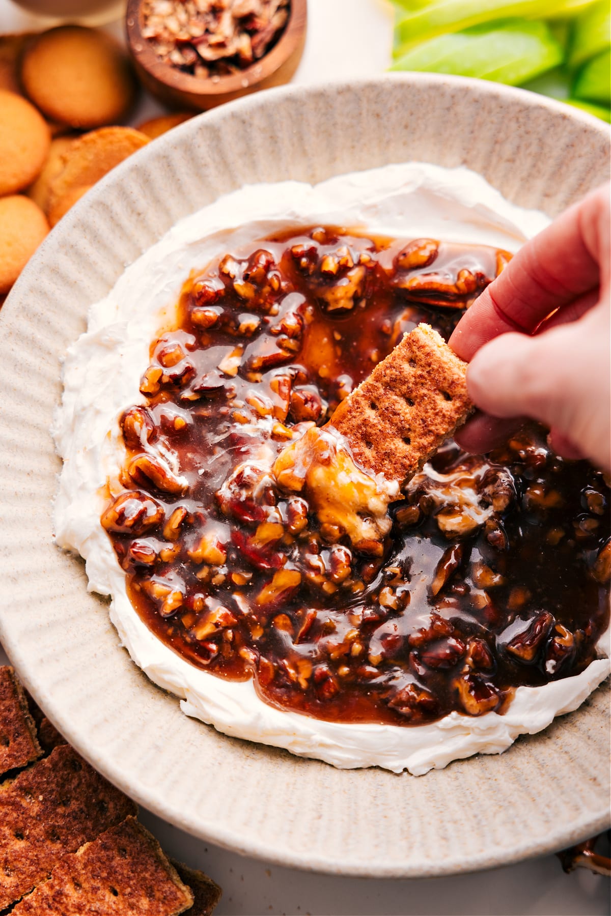 Pecan Pie Dip Is A Must Have This Thanksgiving A scoop of creamy fall pecan pie dip with a graham cracker being dipped in.